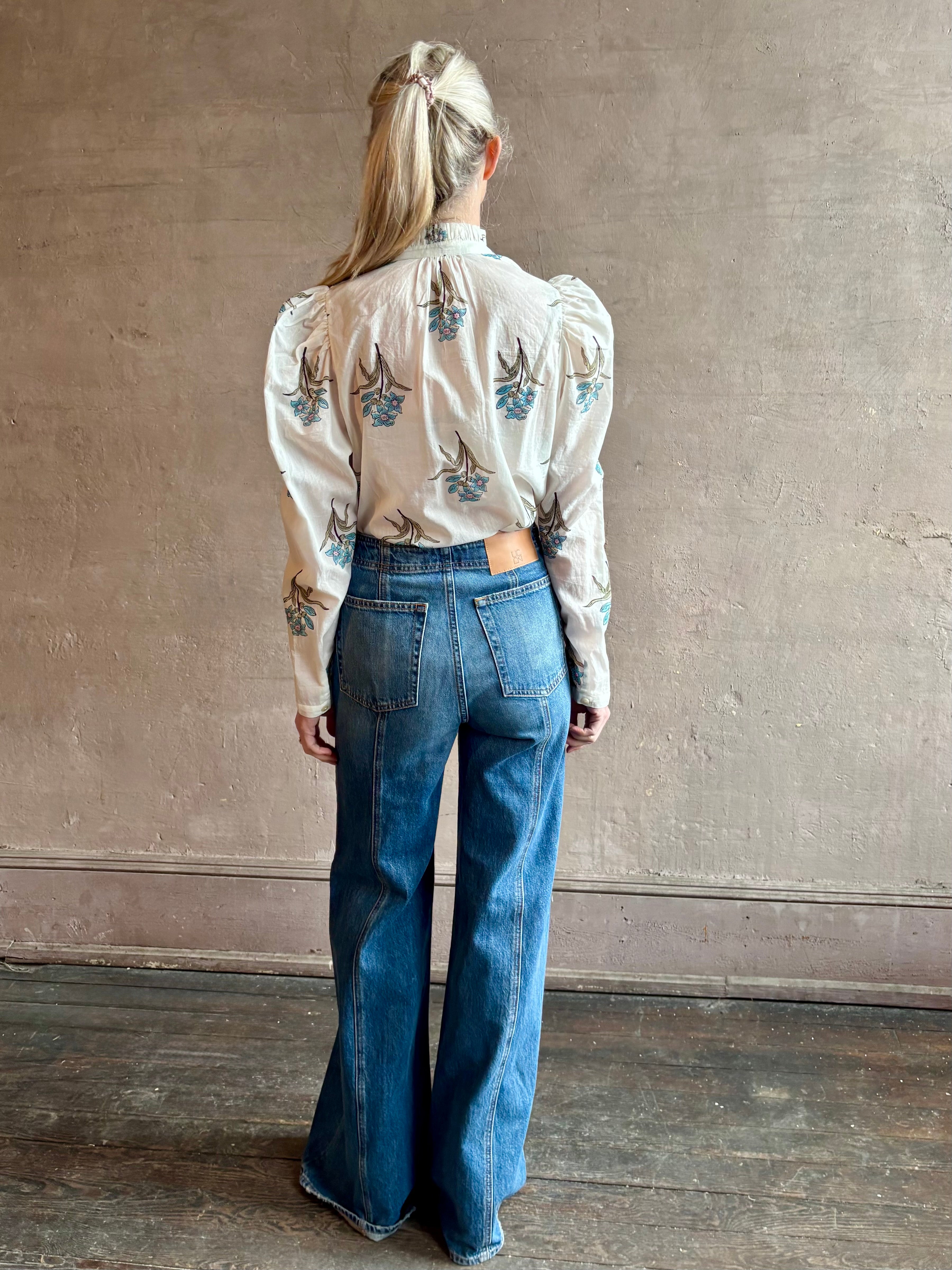 Image of woman wearing ALIX OF BOHEMIA Artemis Sky Mist Flower Shirt with Off-White background and aqua and pink floral print