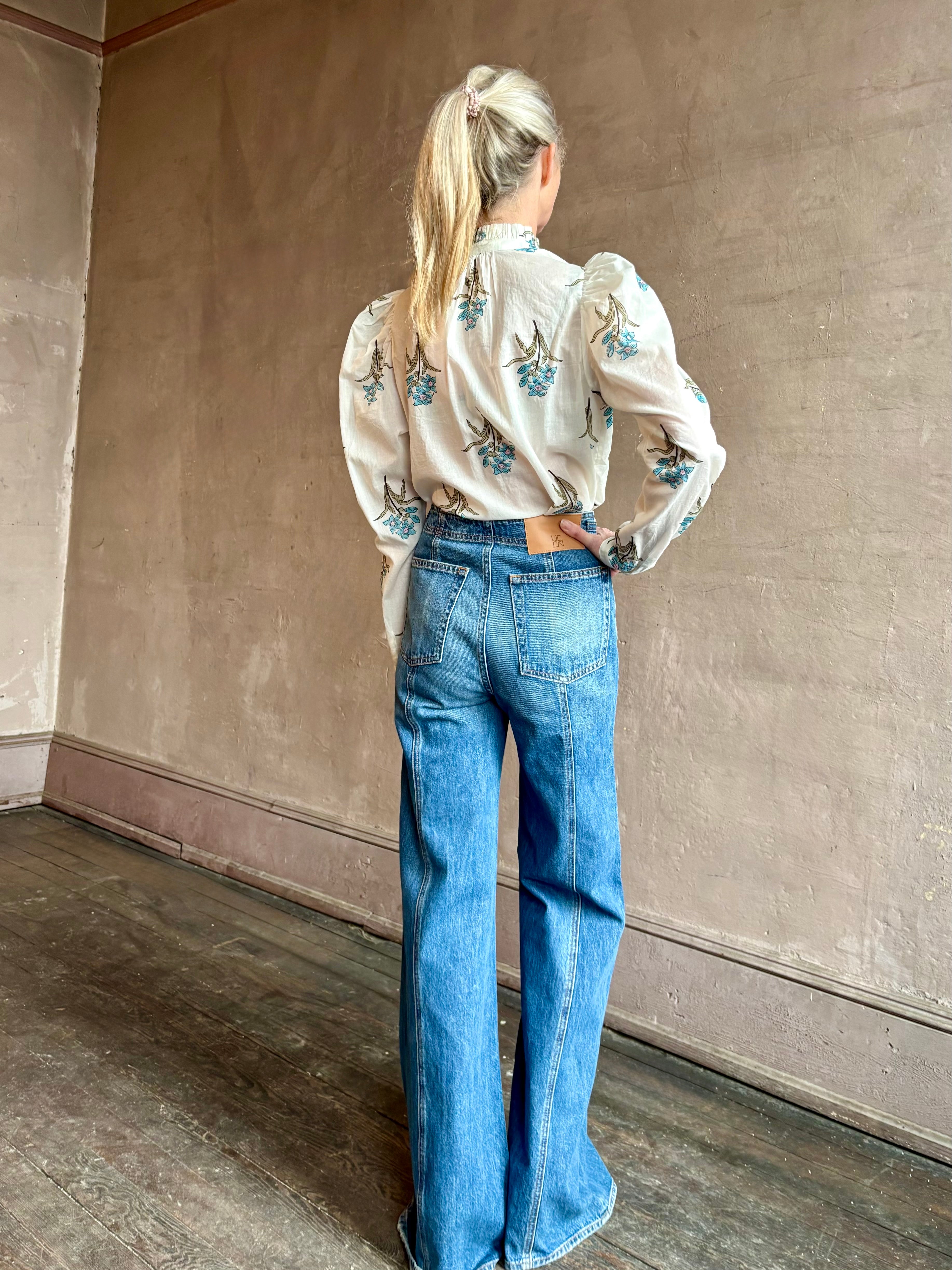 Image of woman wearing ALIX OF BOHEMIA Artemis Sky Mist Flower Shirt with Off-White background and aqua and pink floral print