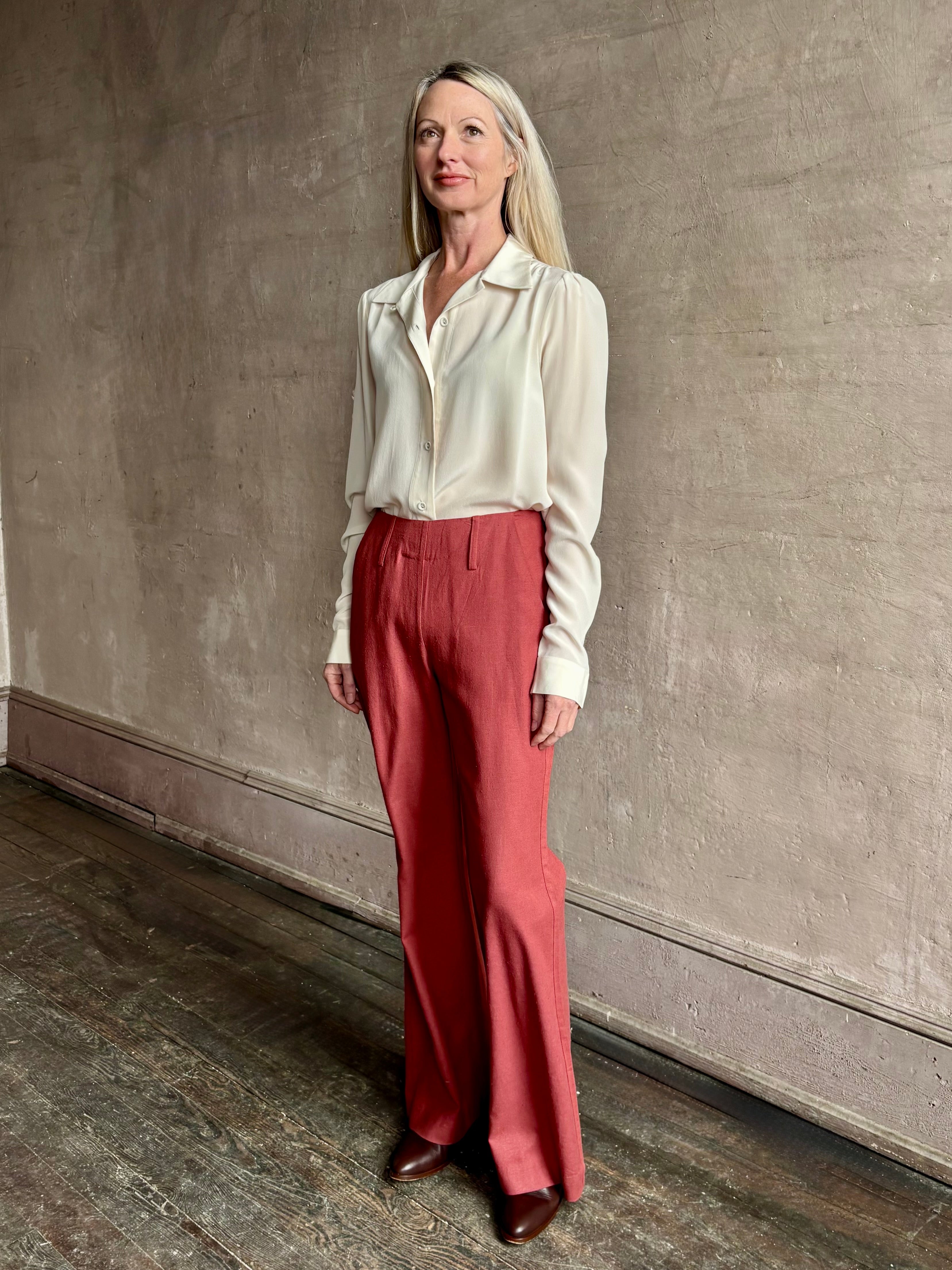 Woman wearing sophisticated ALIX OF BOHEMIA Charlie Red Ochre Silk Pant with belt loops, flat front and full length straight leg