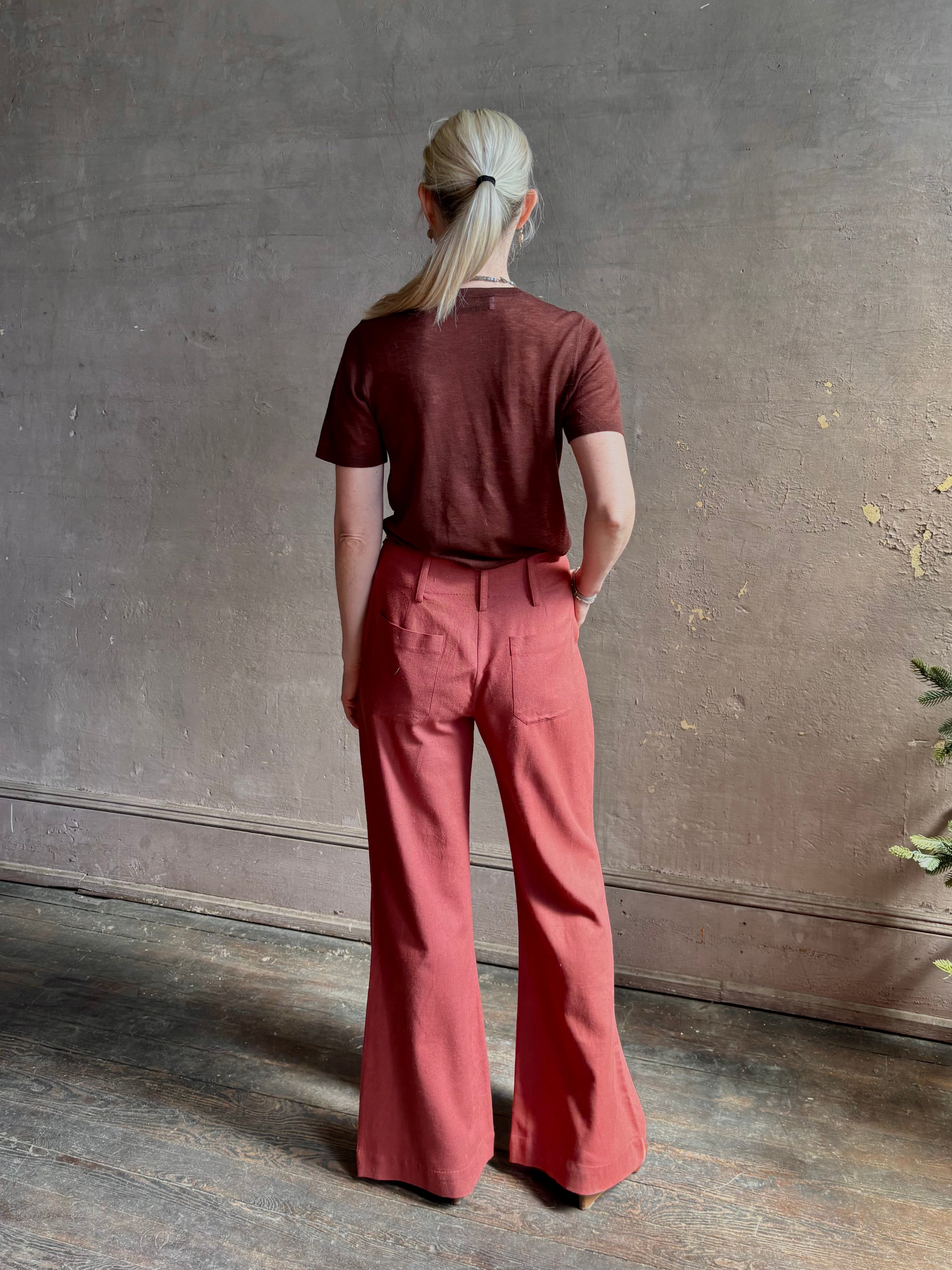 Woman wearing sophisticated ALIX OF BOHEMIA Charlie Red Ochre Silk mid-rise Pant with front and back pockets, belt loops, flat front and full length straight leg