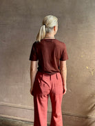 Woman wearing sophisticated ALIX OF BOHEMIA Charlie Red Ochre Silk mid-rise Pant with front and back pockets, belt loops, flat front and full length straight leg
