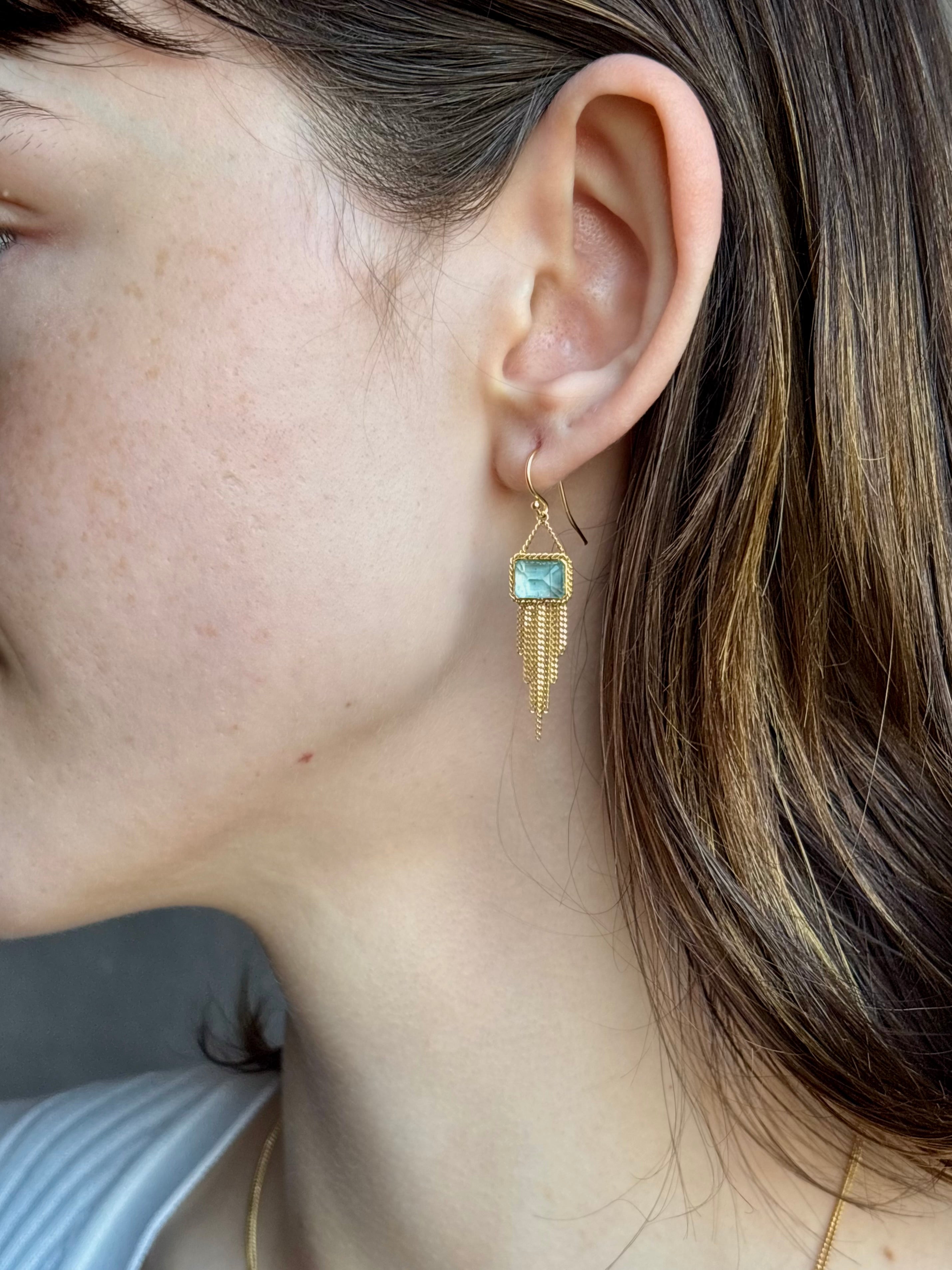Woman wearing handmade New York designer Amali rectangular aquamarine and 18k yellow gold drop earrings with elegant  gold fringe dangle embellishments