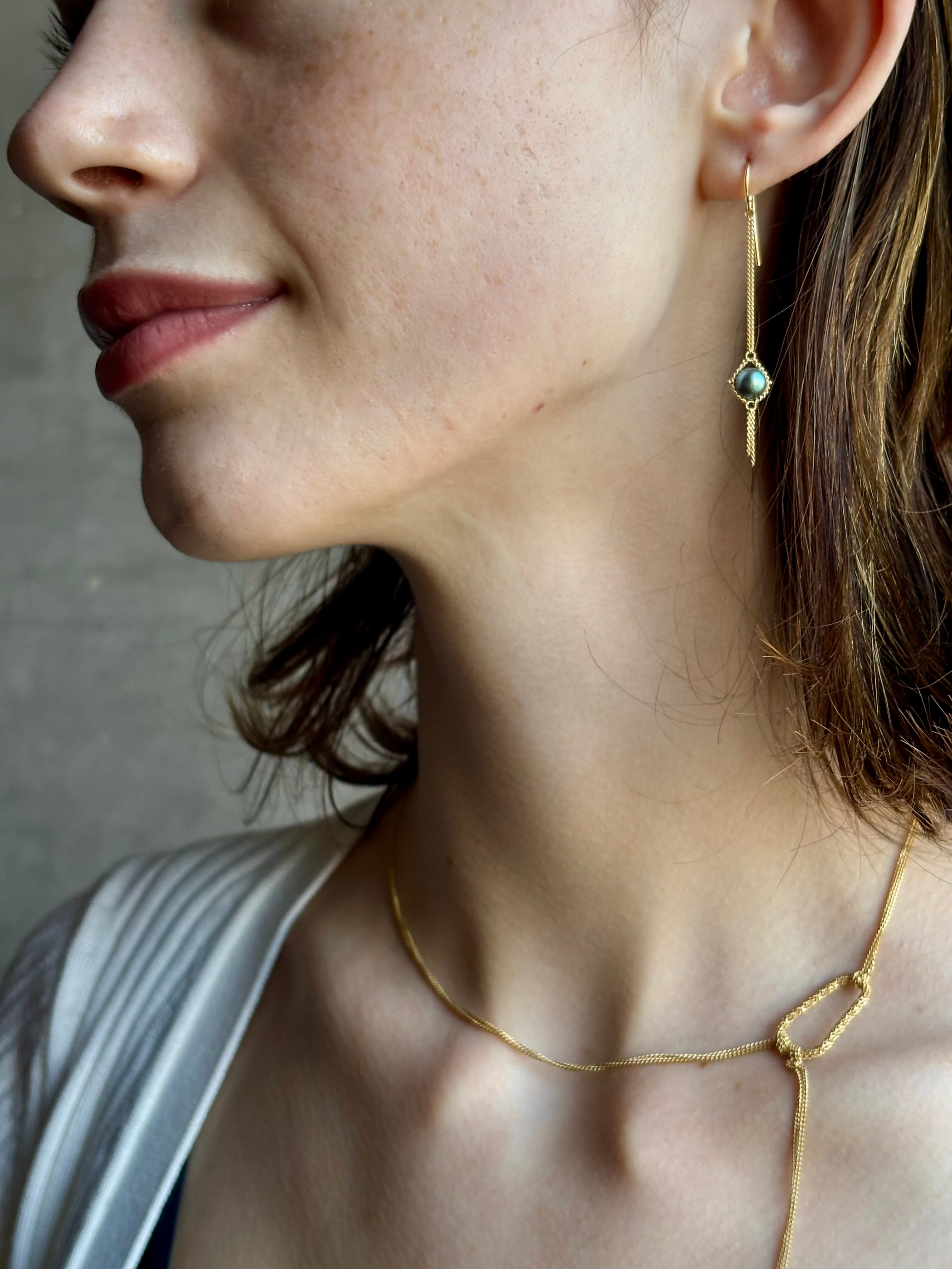 Woman wearing refined fine jewelry with iridescent blue Akoya pearls in an elegantly wearable drop silhouette in 18k yellow gold from New york designer Amali with kinetic  fun fringe bottom detail