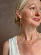 Mature woman wearing a double layered chain natural blue diamond necklace from fine jewelry designer Amali handcrafted in Chapel Hill North Carolina in warm 18K yellow gold