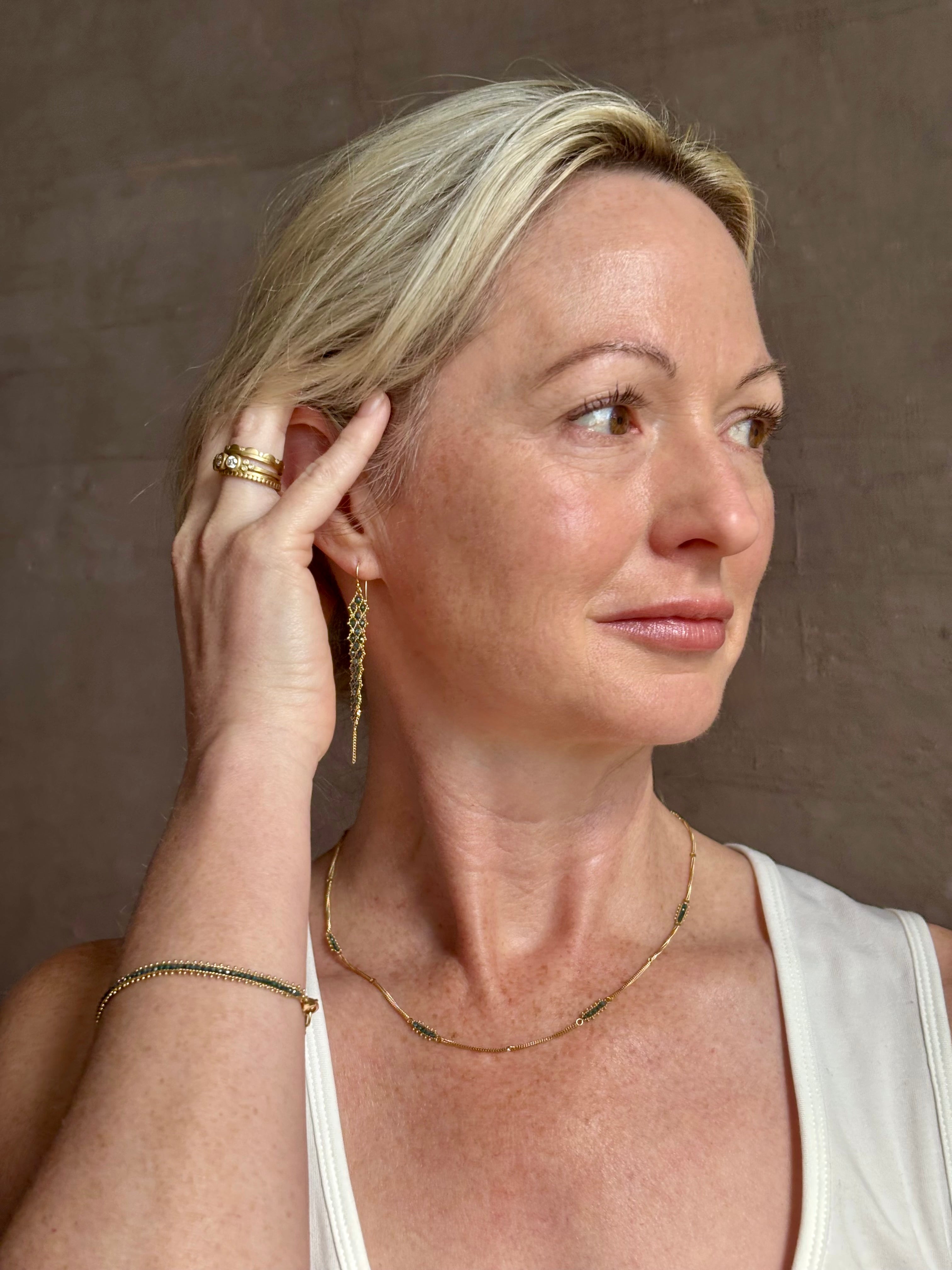 Mature woman wearing a double layered chain natural blue diamond necklace from fine jewelry designer Amali handcrafted in Chapel Hill North Carolina in warm 18K yellow gold