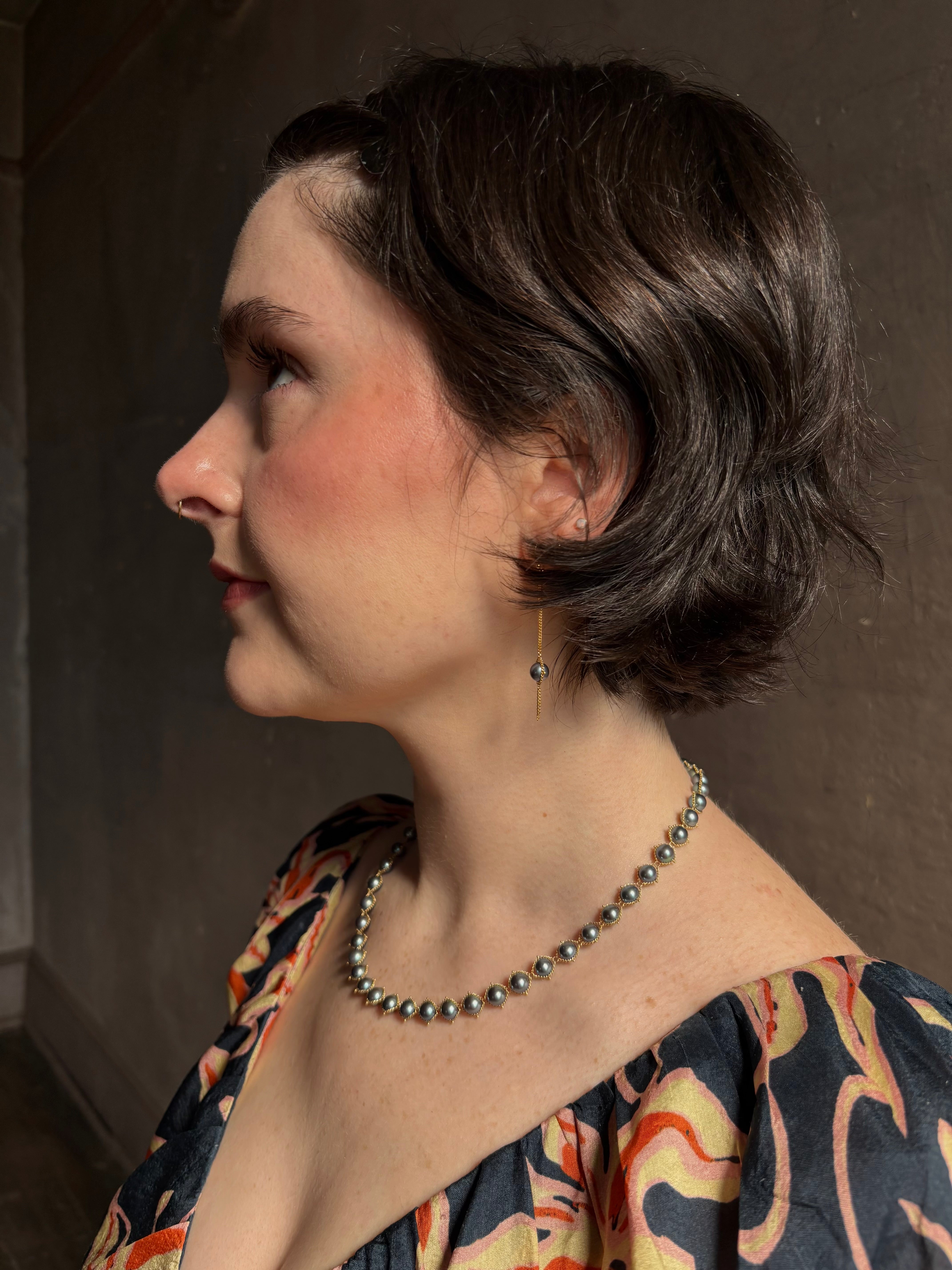 Woman wearing luxury Grey Akoya Pearl Necklace from fine jewelry artist Amali handcrafted in New York in warm 18K yellow gold with matching earrings