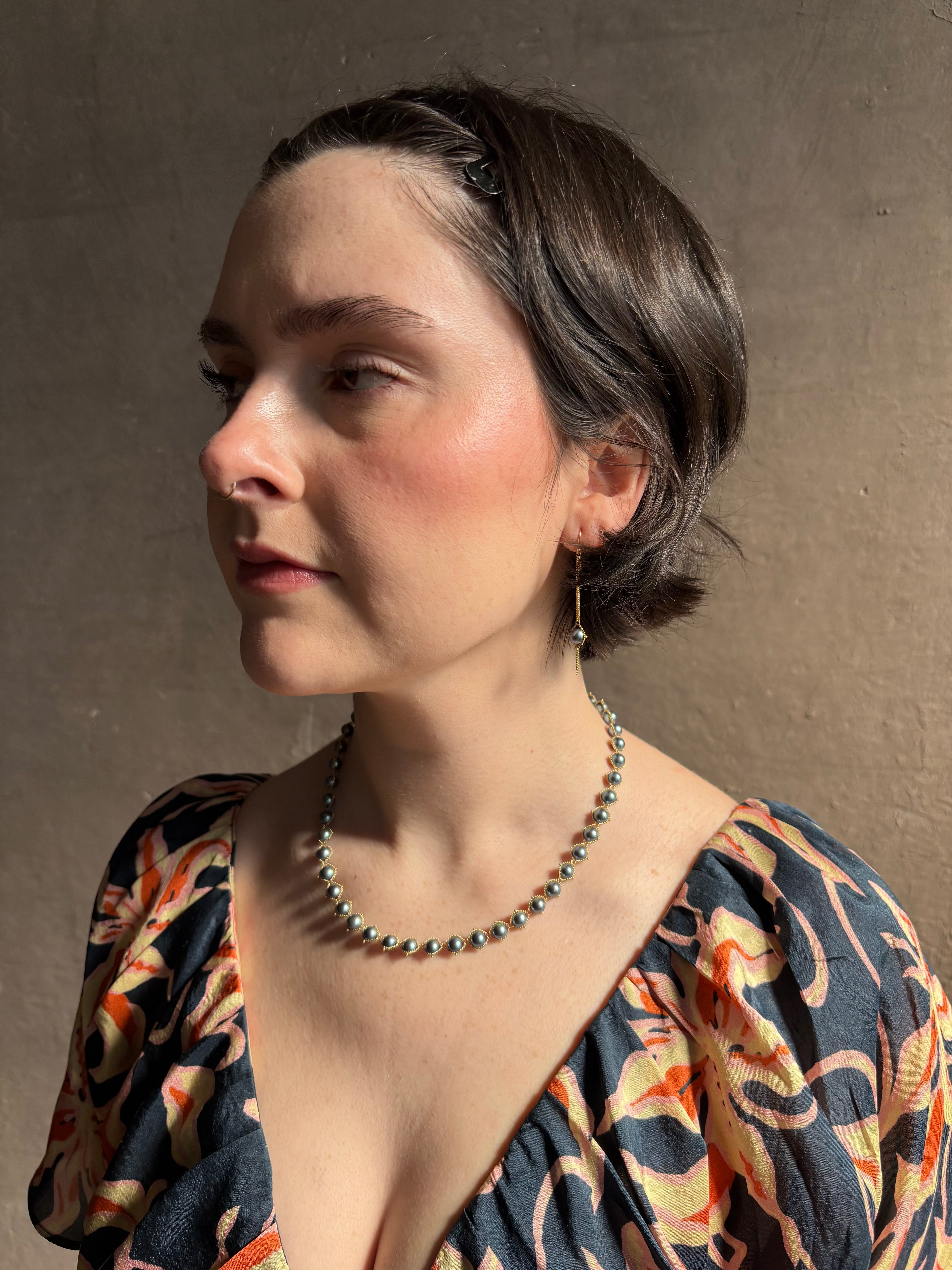 Woman wearing luxury Grey Akoya Pearl Necklace from fine jewelry artist Amali handcrafted in New York in warm 18K yellow gold with matching earrings