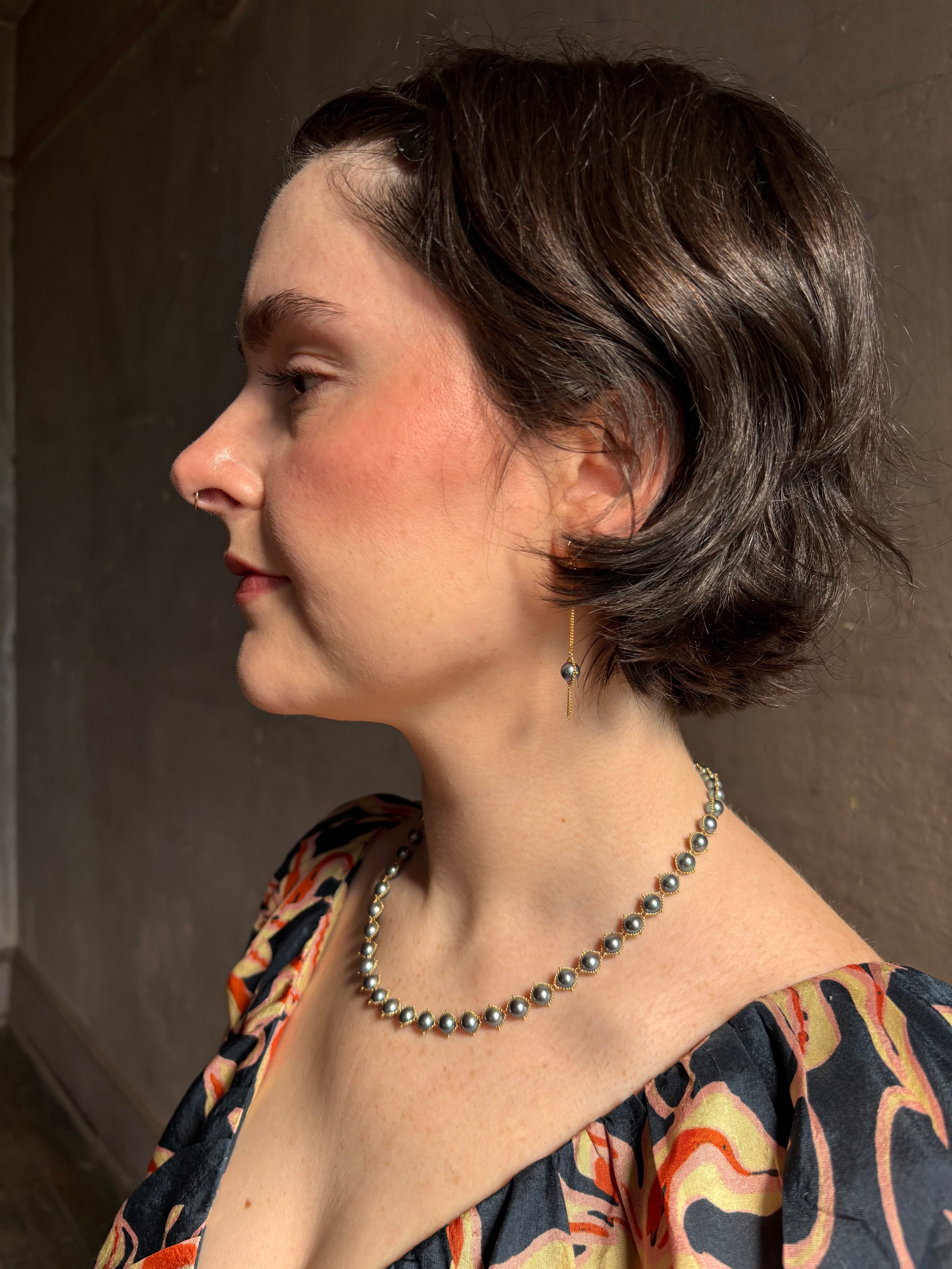 Woman wearing luxury Grey Akoya Pearl Necklace from fine jewelry artist Amali handcrafted in New York in warm 18K yellow gold with matching earrings