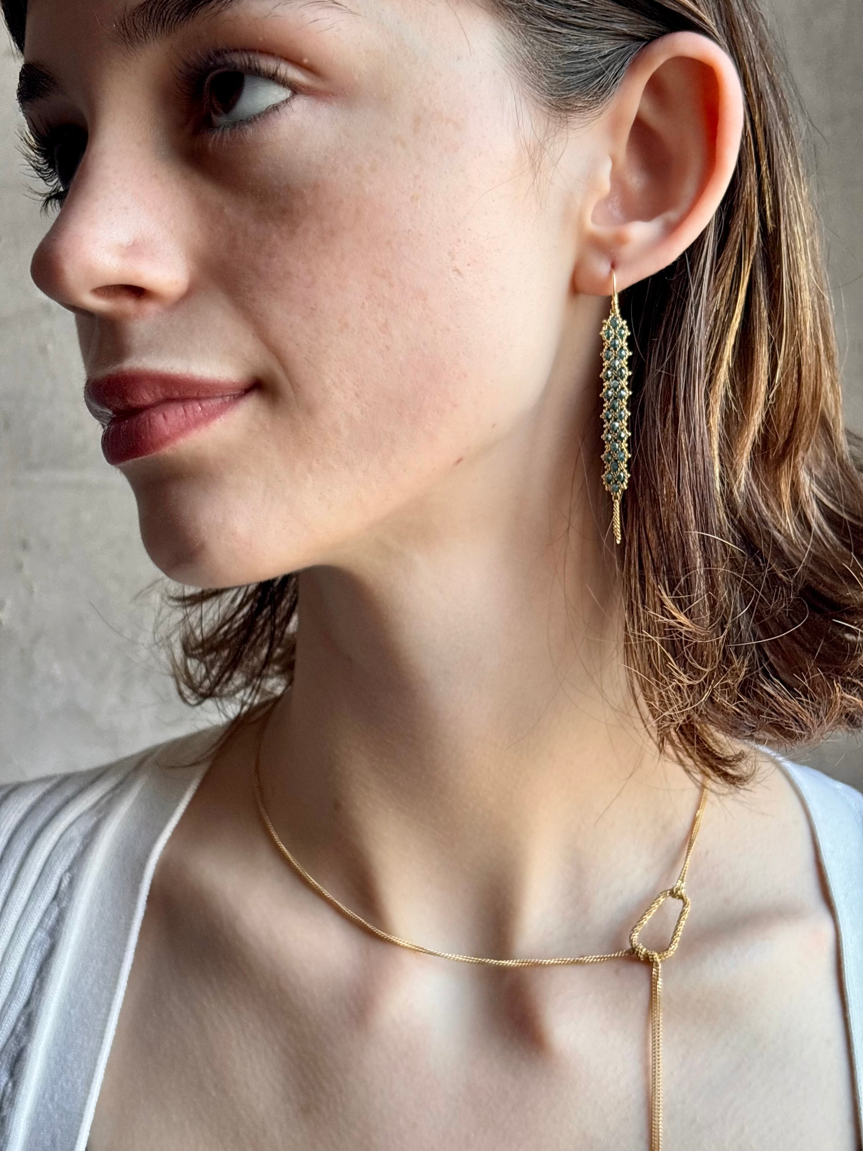 Woman wearing 18k yellow gold stardust Lariat Necklace from fine jewelry artist Amali and handmade in New York. Designed to be worn asymmetrically to the side offering a modern, fashion-forward twist to a classic