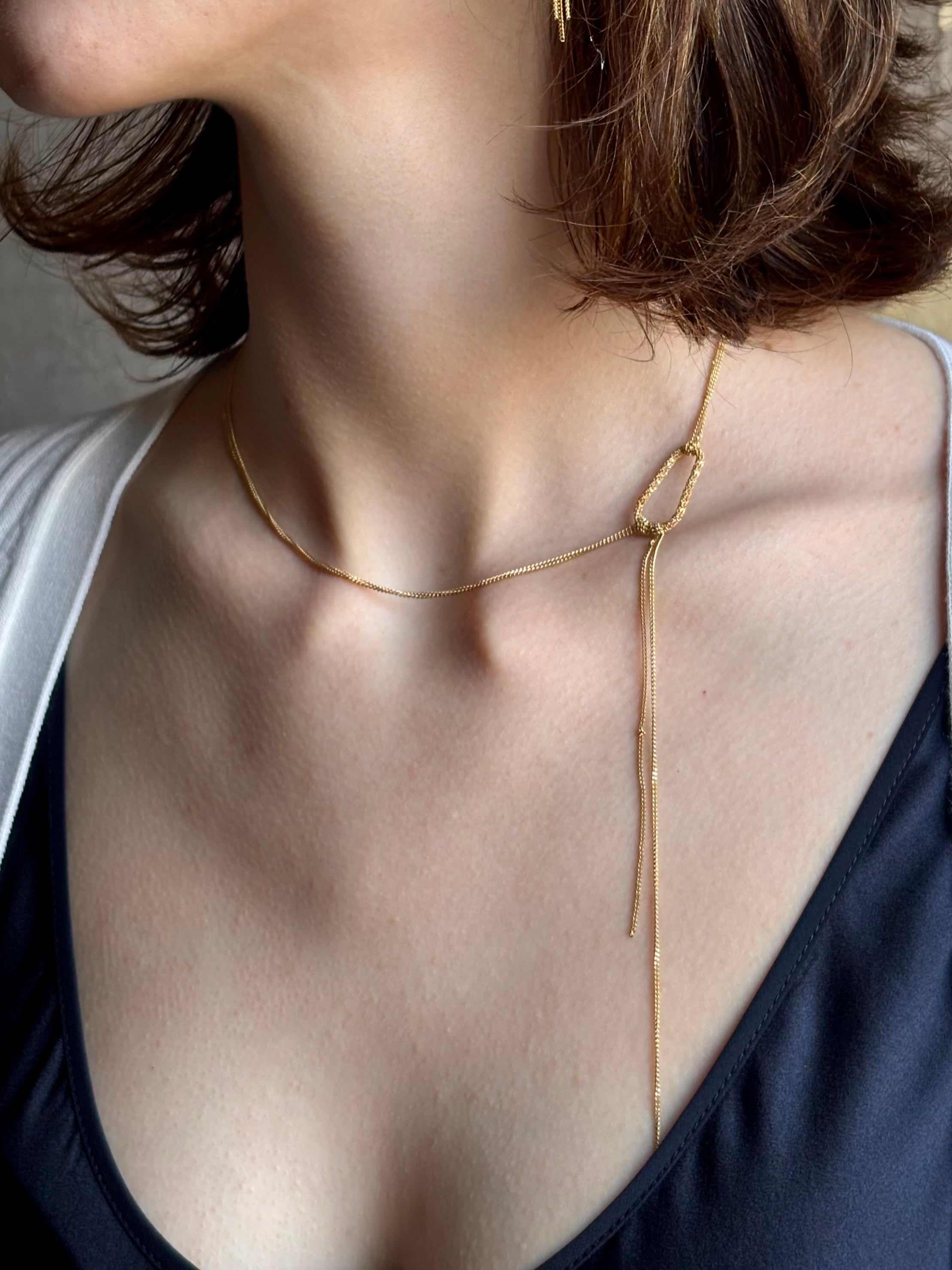 Woman wearing 18k yellow gold stardust Lariat Necklace from fine jewelry artist Amali and handmade in New York. Designed to be worn asymmetrically to the side offering a modern, fashion-forward twist to a classic