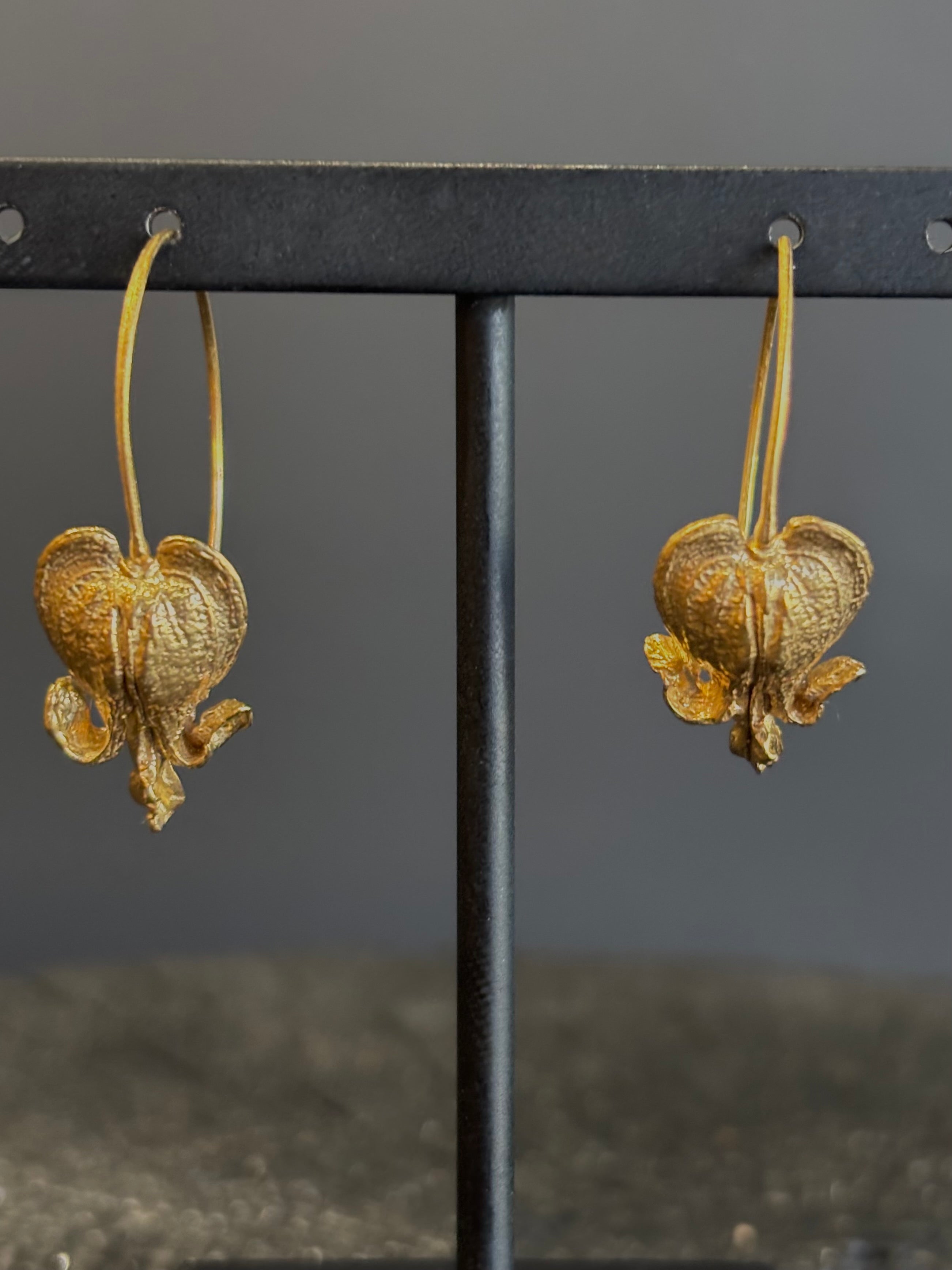 Image of Bleeding Heart Hoop Earrings from North Carolina fine Jewelry artist Amber Mahler handcrafted 18K yellow gold vermeil botanical casting. 