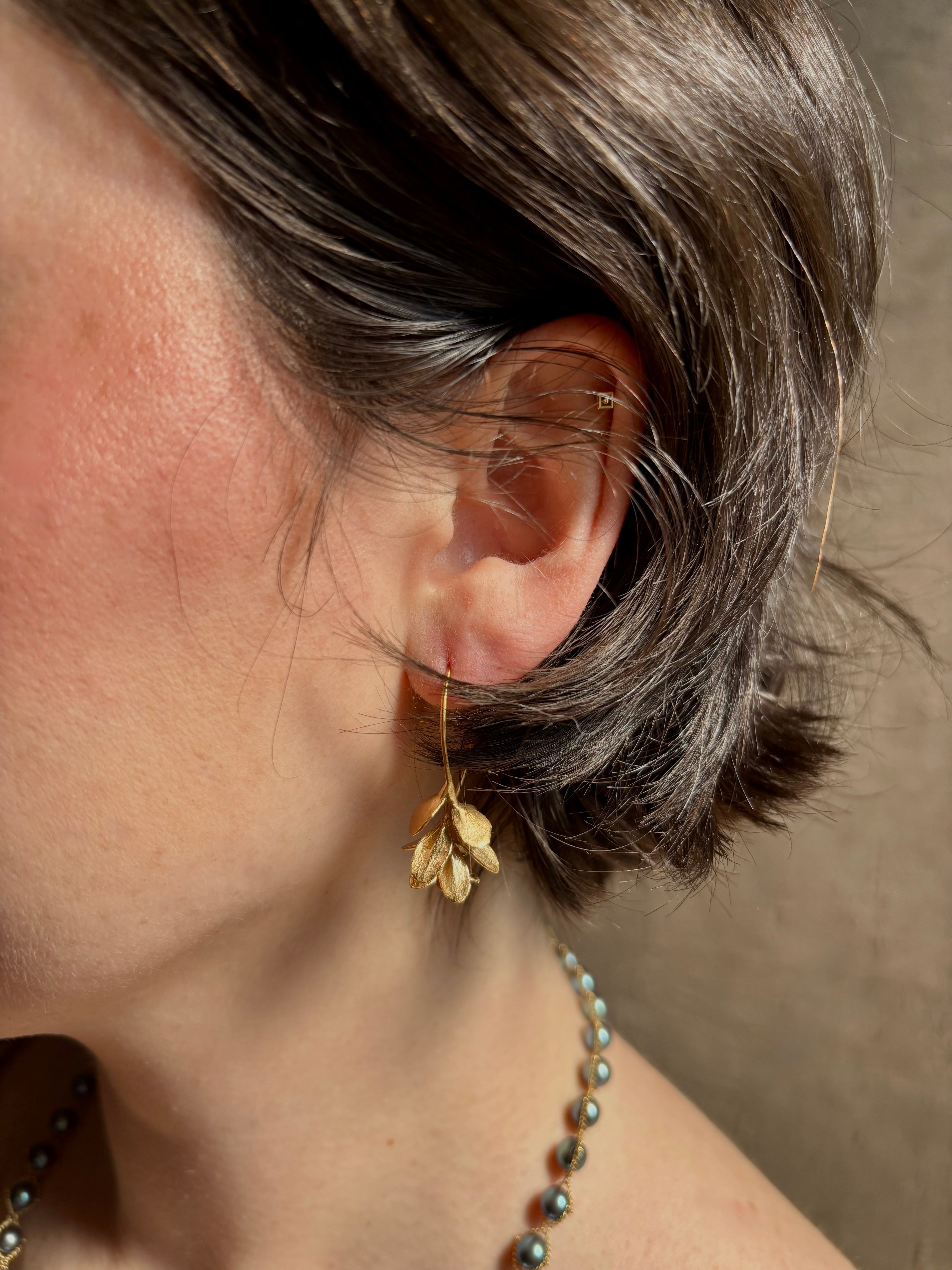 Woman wearing Four Petal Succulent Hoop Earrings from North Carolina fine jewelry artist Amber Mahler handcrafted 18K yellow gold vermeil botanical casting