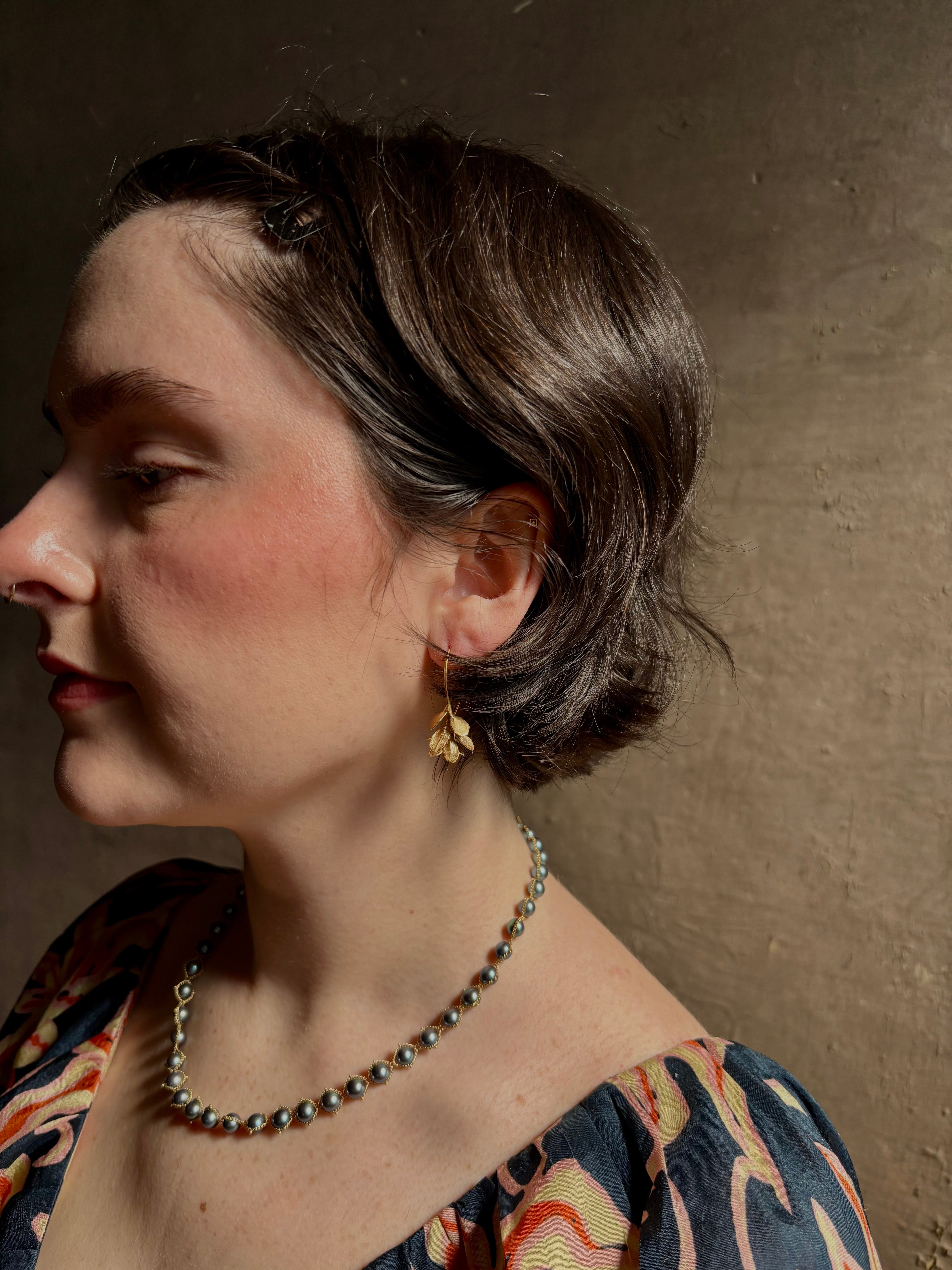 Woman wearing Four Petal Succulent Hoop Earrings from North Carolina fine jewelry artist Amber Mahler handcrafted 18K yellow gold vermeil botanical casting
