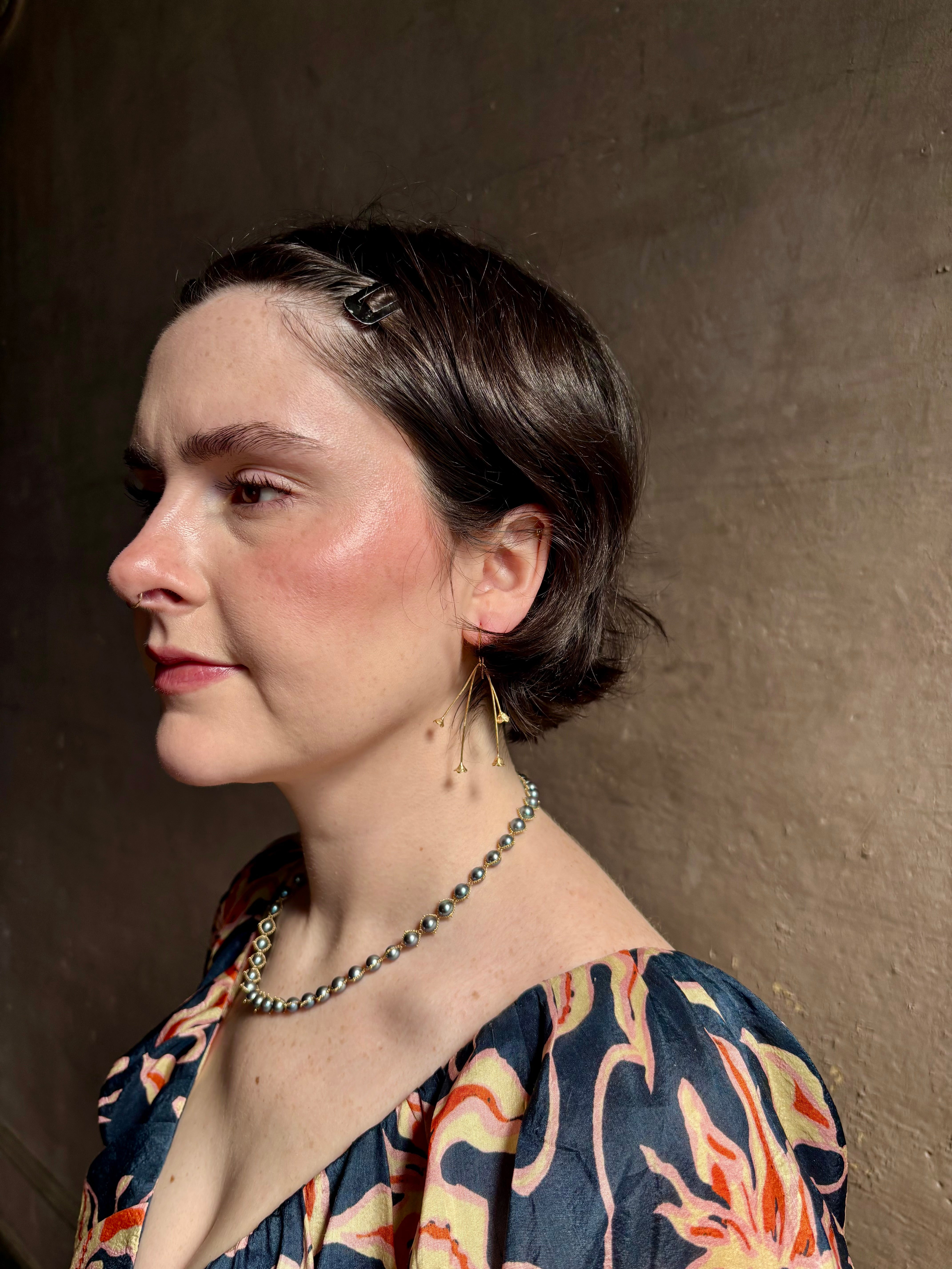 Woman wearing Lily of the Valley Earrings from North Carolna fine jewelry artist Amber Mahler handcrafted 18K yellow gold vermeil with four dangling flower blossoms