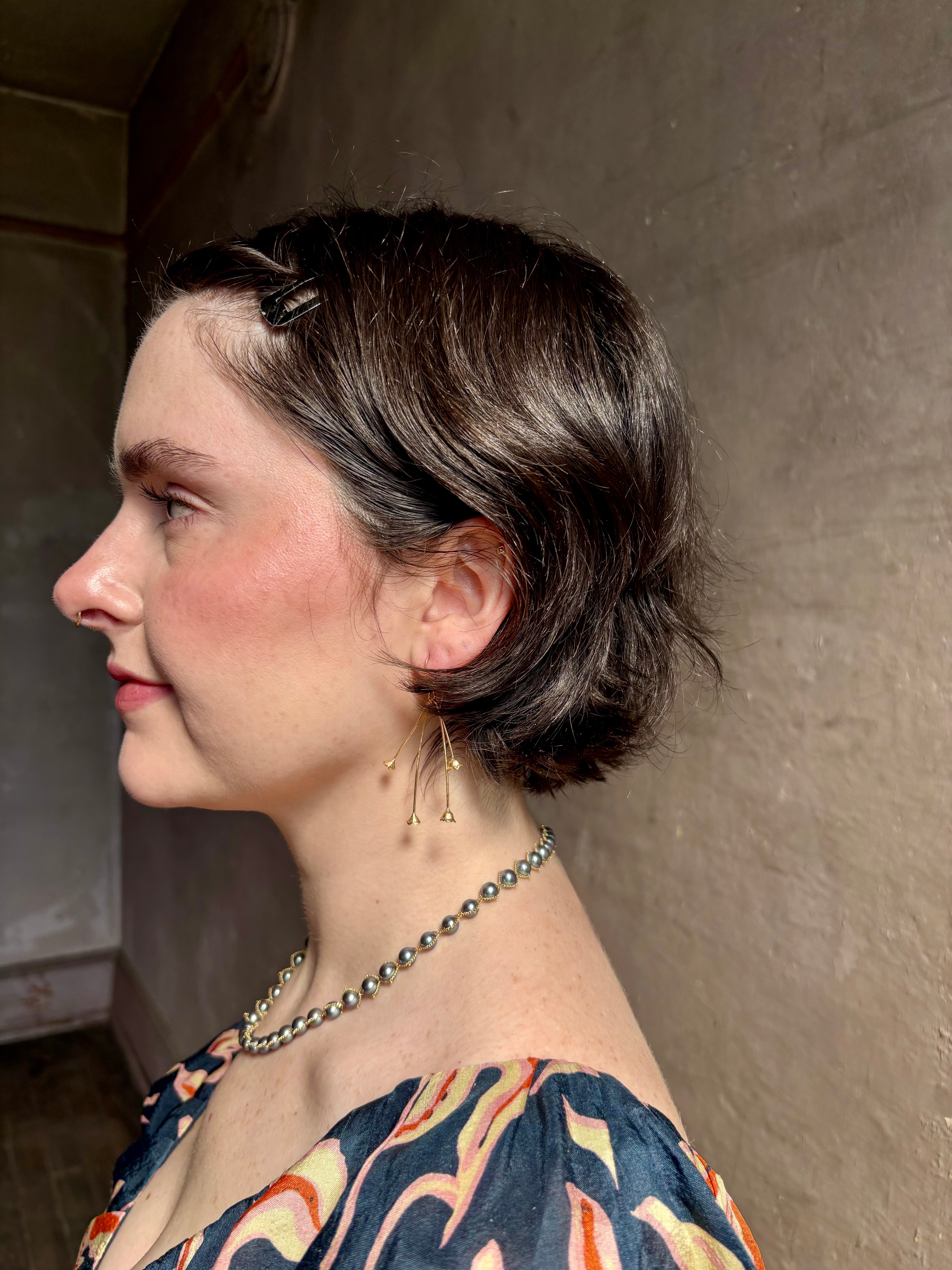 Woman wearing Lily of the Valley Earrings from North Carolna fine jewelry artist Amber Mahler handcrafted 18K yellow gold vermeil with four dangling flower blossoms
