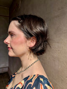 Woman wearing Lily of the Valley Earrings from North Carolna fine jewelry artist Amber Mahler handcrafted 18K yellow gold vermeil with four dangling flower blossoms