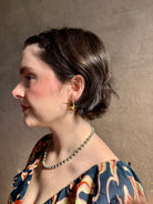 Woman wearing Poppy Pod and Blueberry Branch post Earrings from North Carolina fine jewelry artist Amber Mahler handcrafted 18K yellow gold vermeil casting. 