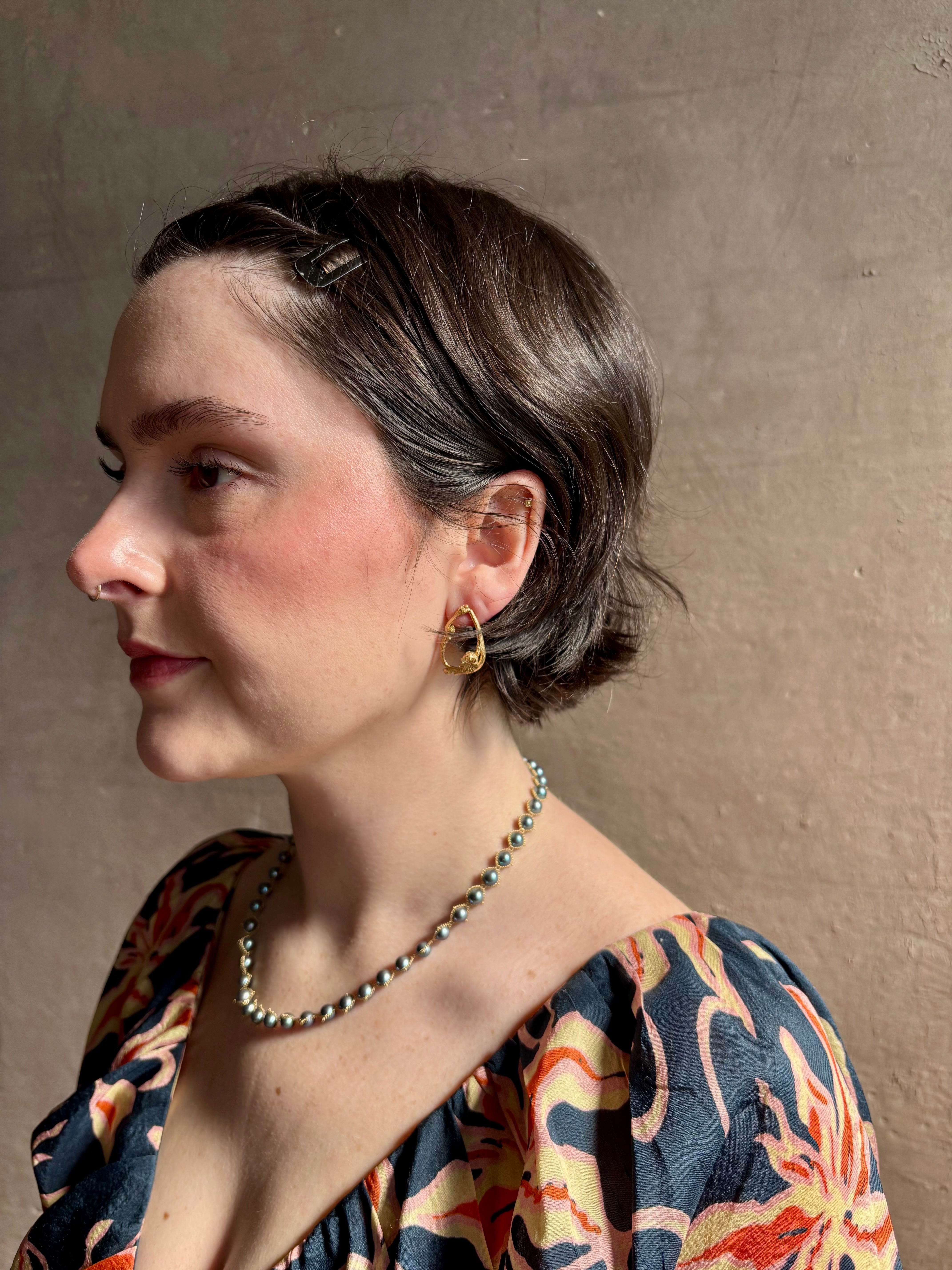 Woman wearing Poppy Pod and Blueberry Branch post Earrings from North Carolina fine jewelry artist Amber Mahler handcrafted 18K yellow gold vermeil casting. 