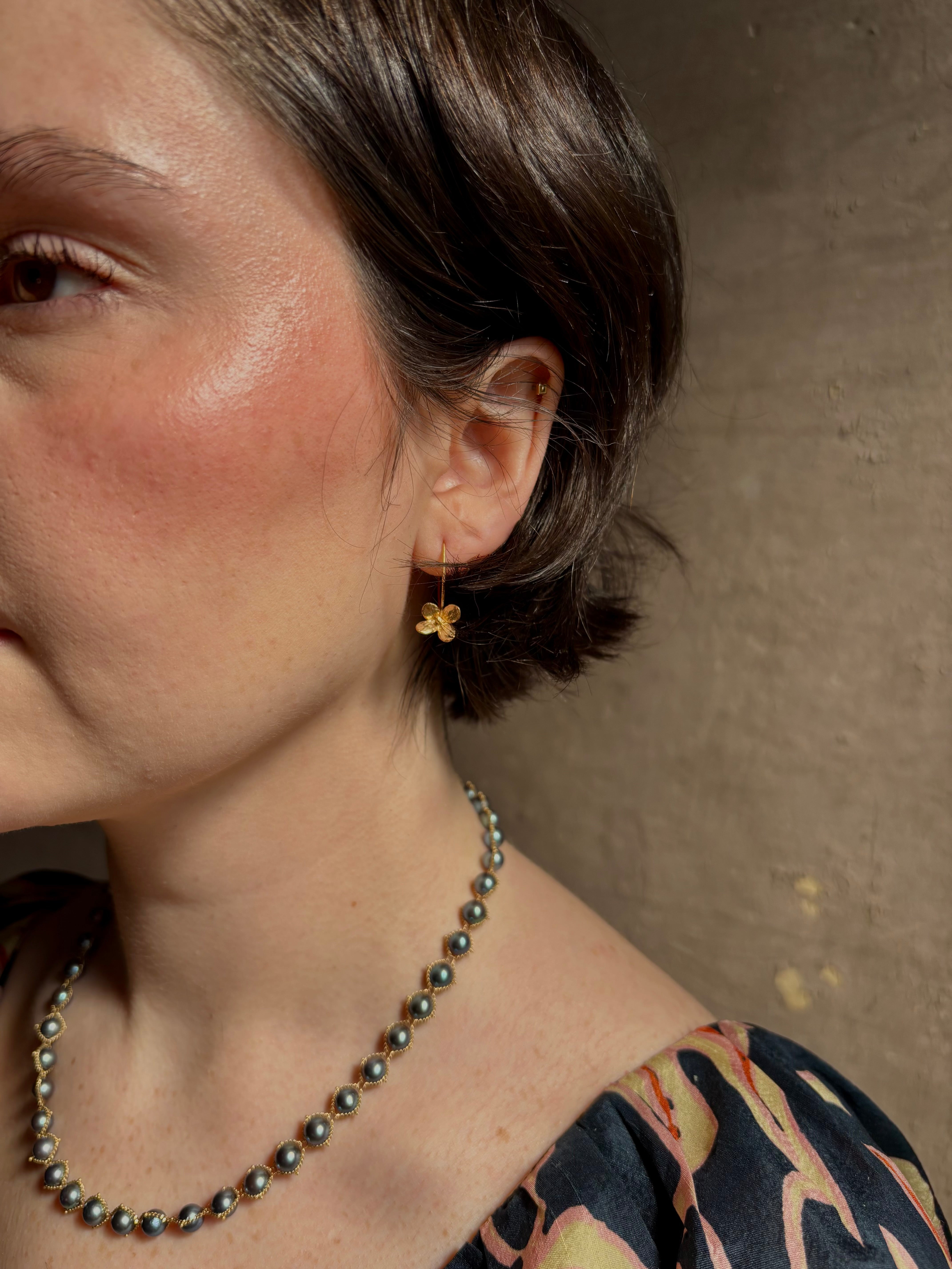 Woman wearing Purslane Rosette Hoop Earrings from North Carolina fine jewelry artist Amber Mahler  handcrafted in 18K yellow gold vermeil cast directly from the purslane rosette