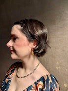 Woman wearing Silver Bells Hoop Earrings from North Carolina fine jewelry artist Amber Mahler in an exquisitely handcrafted 18K yellow gold vermeil botanical casting