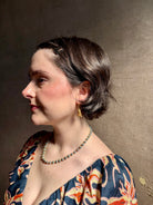 Woman wearing Silver Bells Hoop Earrings from North Carolina fine jewelry artist Amber Mahler in an exquisitely handcrafted 18K yellow gold vermeil botanical casting