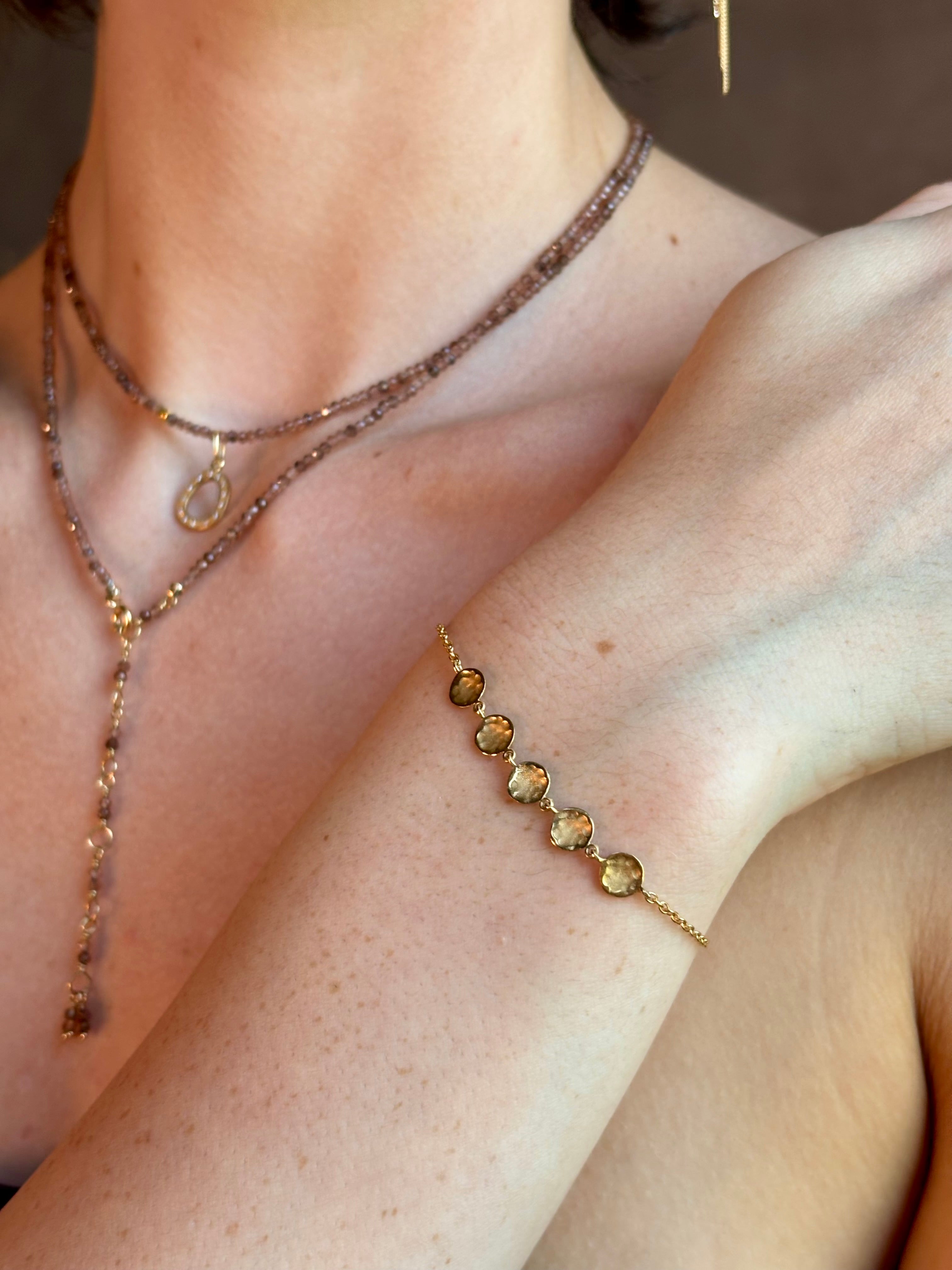 delicate 18K yellow gold bracelet by fine jewelry artist Anne Sportun handcrafted with 5 hammered gold discs