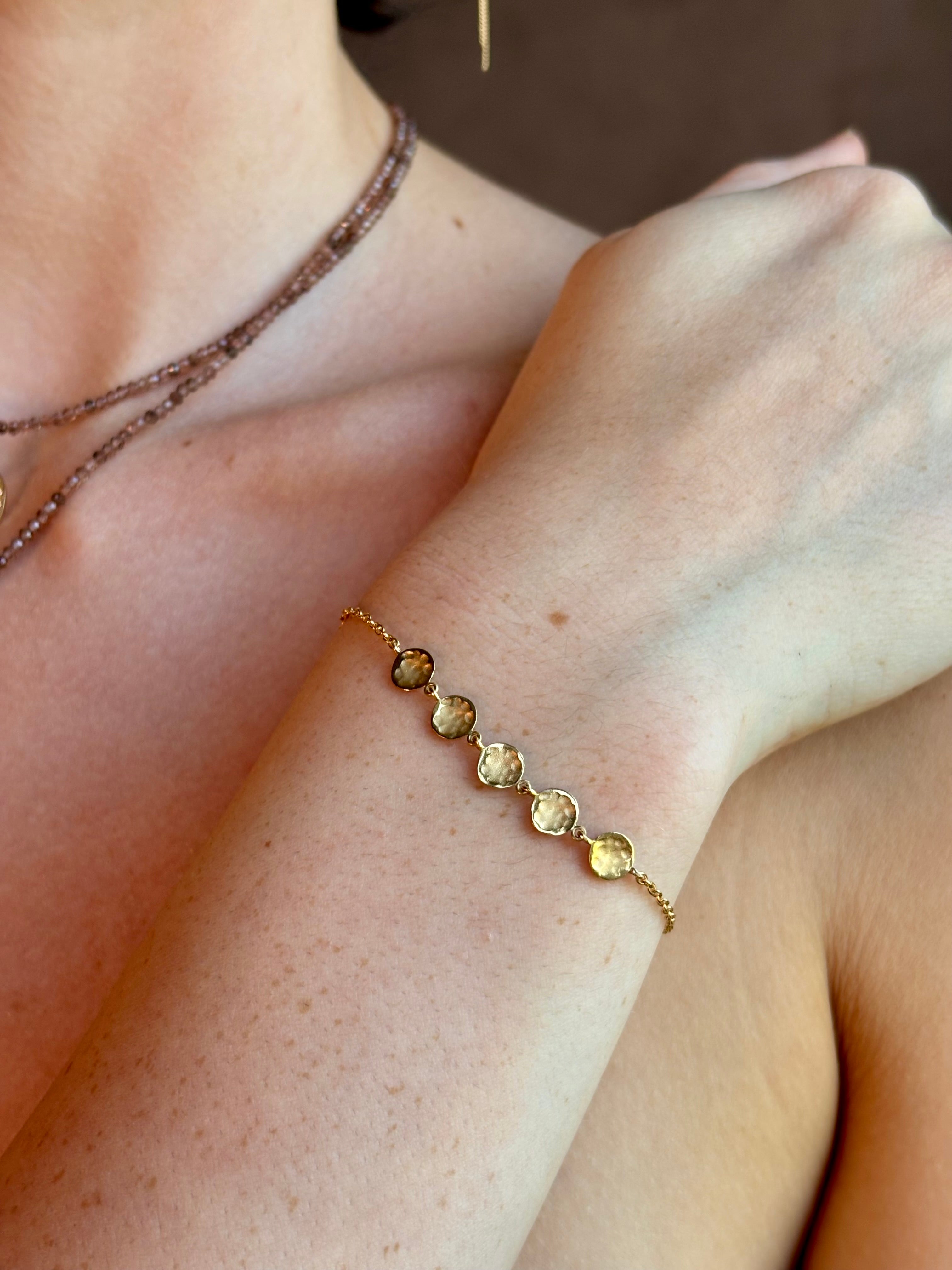 delicate 18K yellow gold bracelet by fine jewelry artist Anne Sportun handcrafted with 5 hammered gold discs