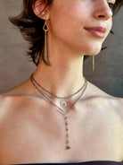 Woman wearing Diamond Charm from Canadian fine jewelry designer Anne Sportun is a perfectly scaled and endlessly versatile jewelry essential. Handcrafted in 18K yellow gold and set with 13 individually quality diamonds in an organic circular form