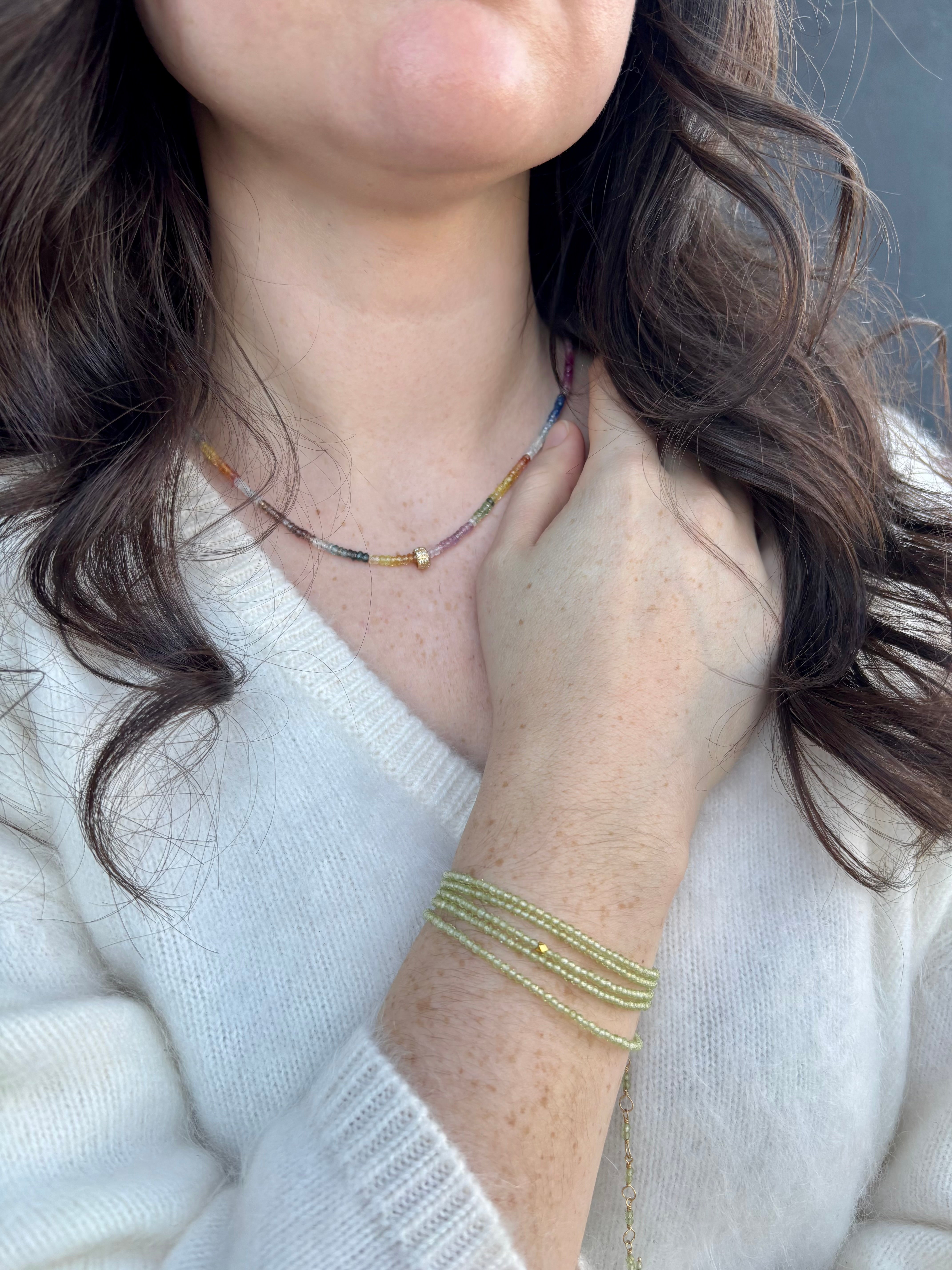 Image of a woman wearing premium peridot and gold bracelet that can also be worn as a necklace by Canadian designer Anne Sportun