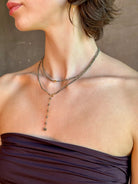 Woman wearing Pyrite River wrap Bracelet from Canadian fine jewelry artist Anne Sportun with pyrite and 18k yellow gold beads that can double as a necklace perfect for travel