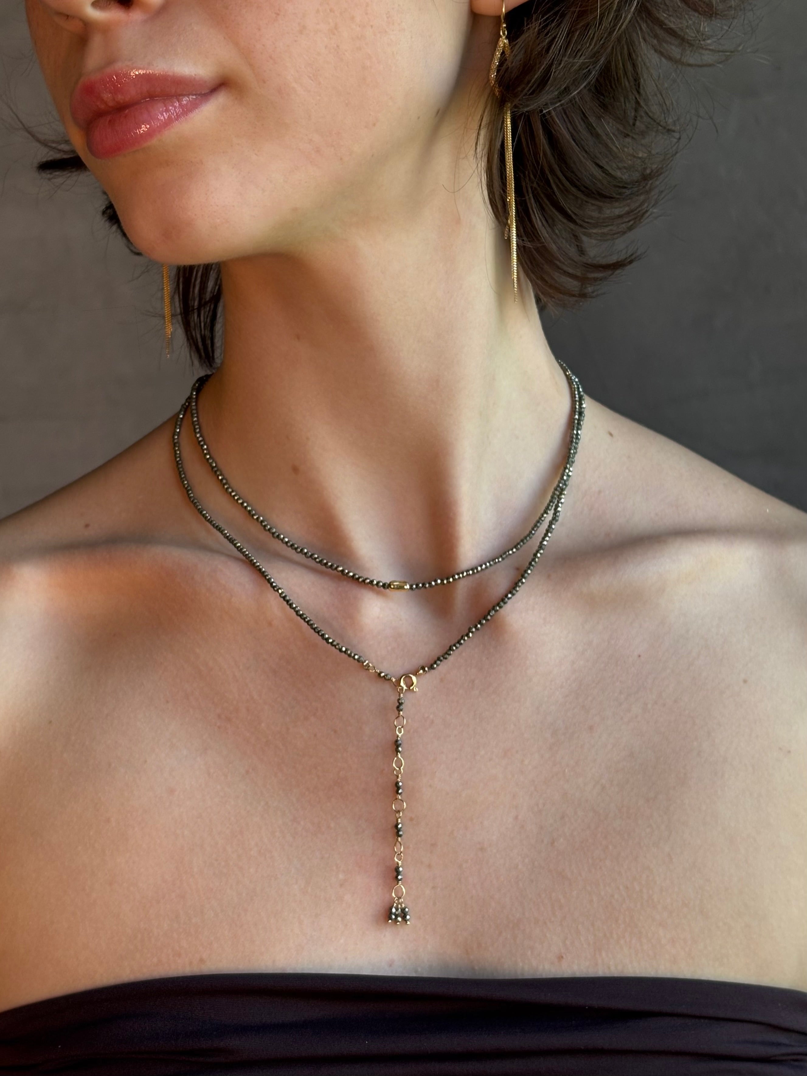 Woman wearing Pyrite River wrap Bracelet from Canadian fine jewelry artist Anne Sportun with pyrite and 18k yellow gold beads that can double as a necklace perfect for travel
