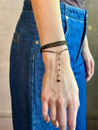 Woman wearing spinel confetti wrap Bracelet from Canadian fine jewelry artist Anne Sportun with natural stone spinel and 18k yellow gold beads that can double as a necklace perfect for travel