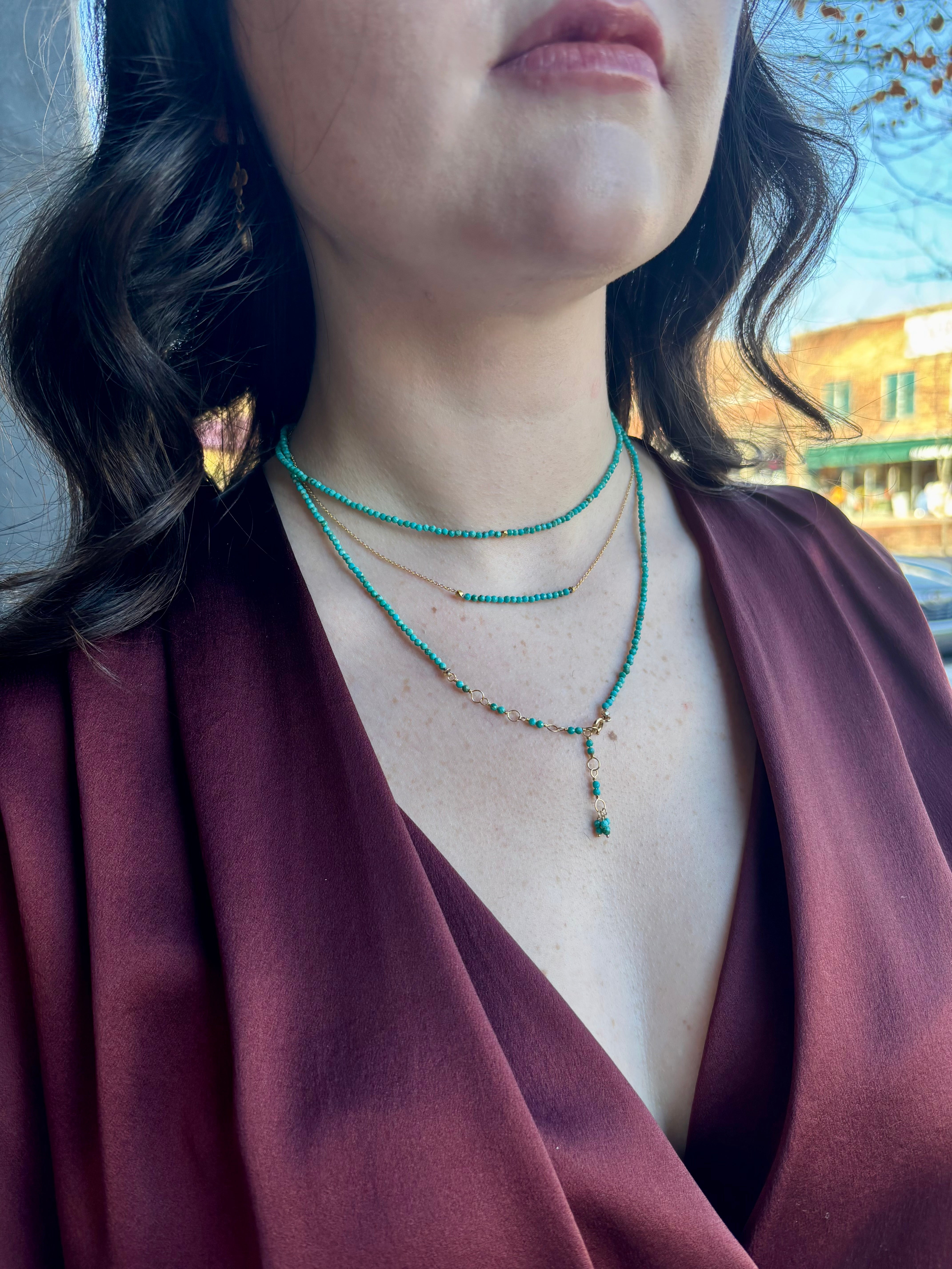 Image of woman wearing Canadian fine Jewelry designer ANNE SPORTUN turquoise wrap Bracelet  as a layering necklace 