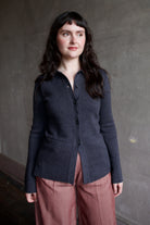Model wearing Apiece Apart Betti dark gray knit cardigan with a button front, long sleeve, collar and front pockets