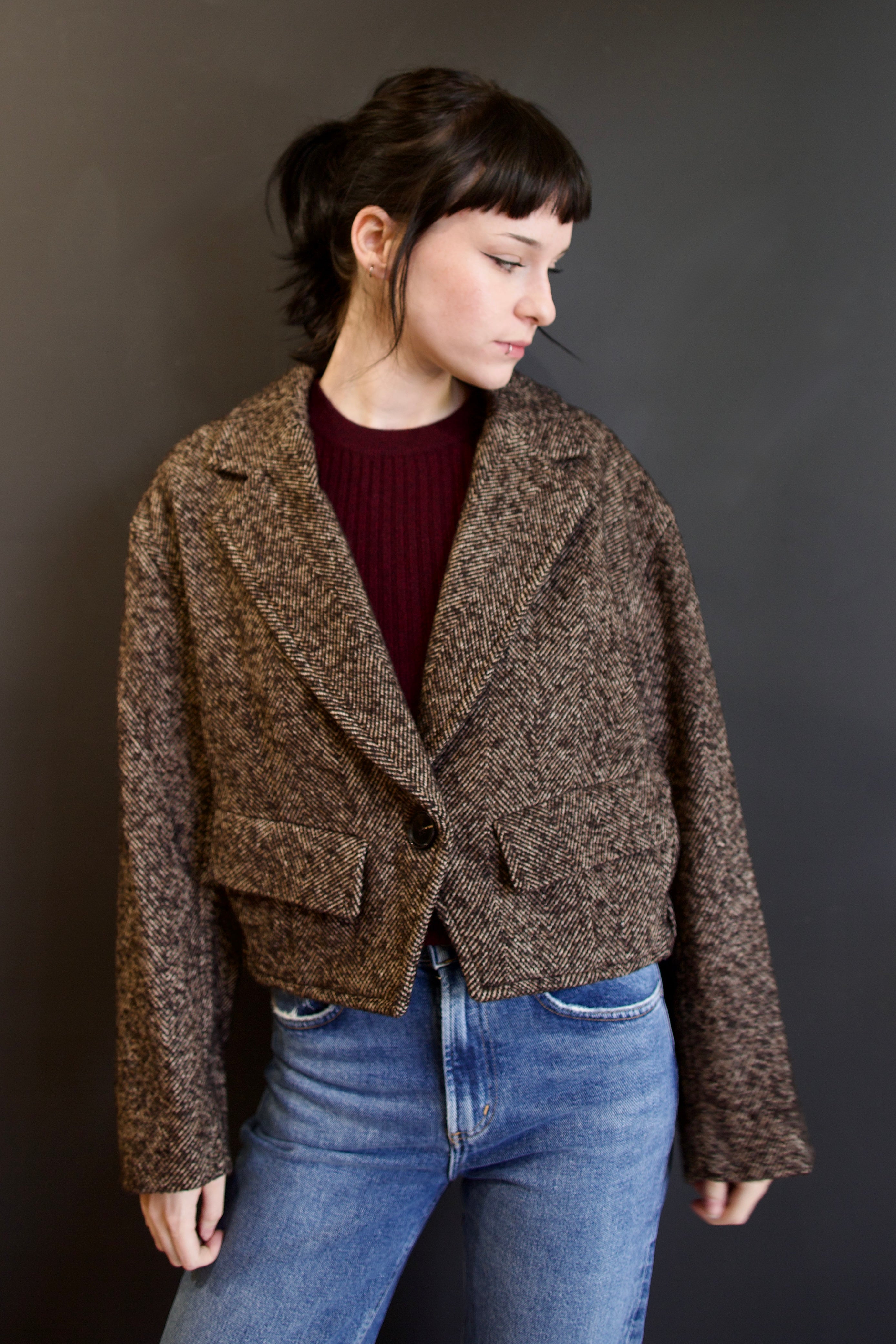 Model wearing environmentally respectful Apiece Apart Ria cropped jacket in a brown textured herringbone