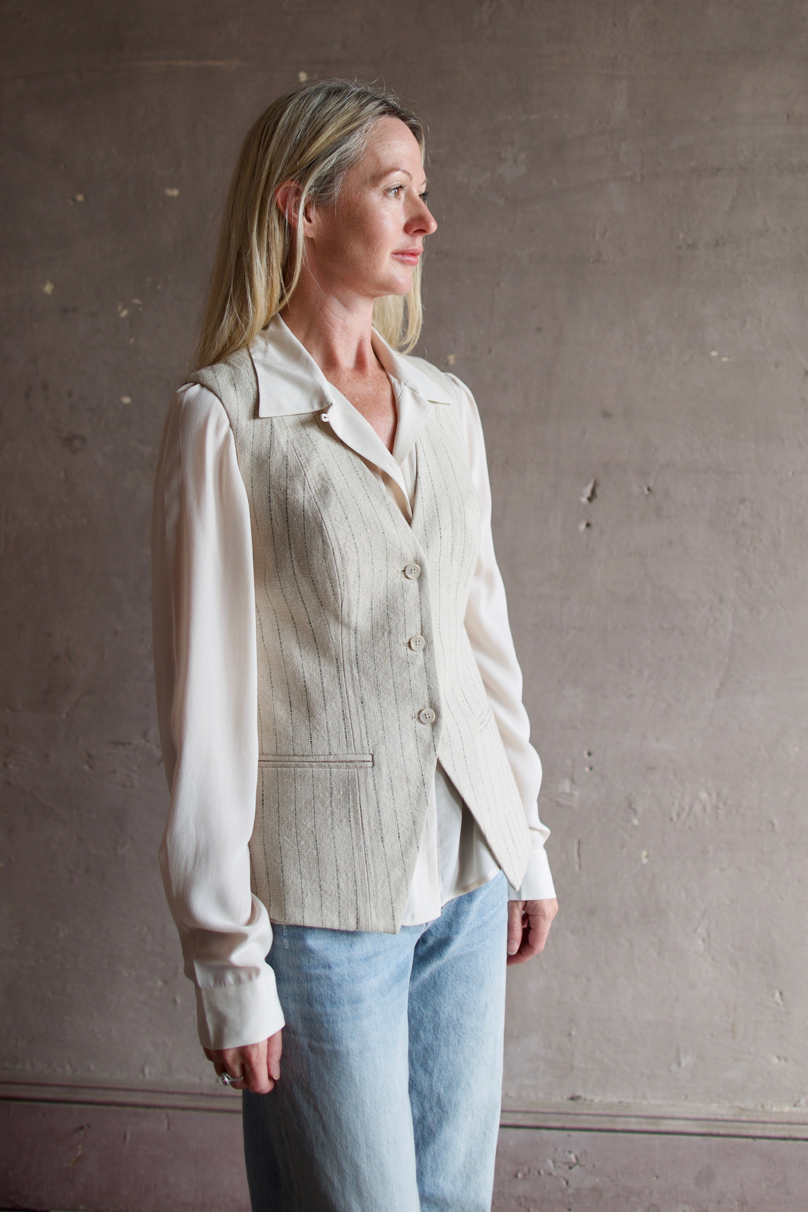 Mature woman wearing luxury brand Apiece Apart Helena Vest with expert sustainable craftsmanship, refined tailoring and neutral layering with button front v- neck