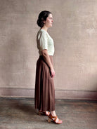 Woman wearing an elevated cream Lia designer Crop Top from Apiece Apart crafted in a breathable summer blend of organic cotton and linen