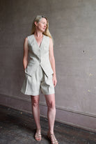 Mature woman wearing luxury brand Apiece Apart Helena Vest and Linaza Shorts in linen with expert sustainable craftsmanship, refined tailoring and long inseam