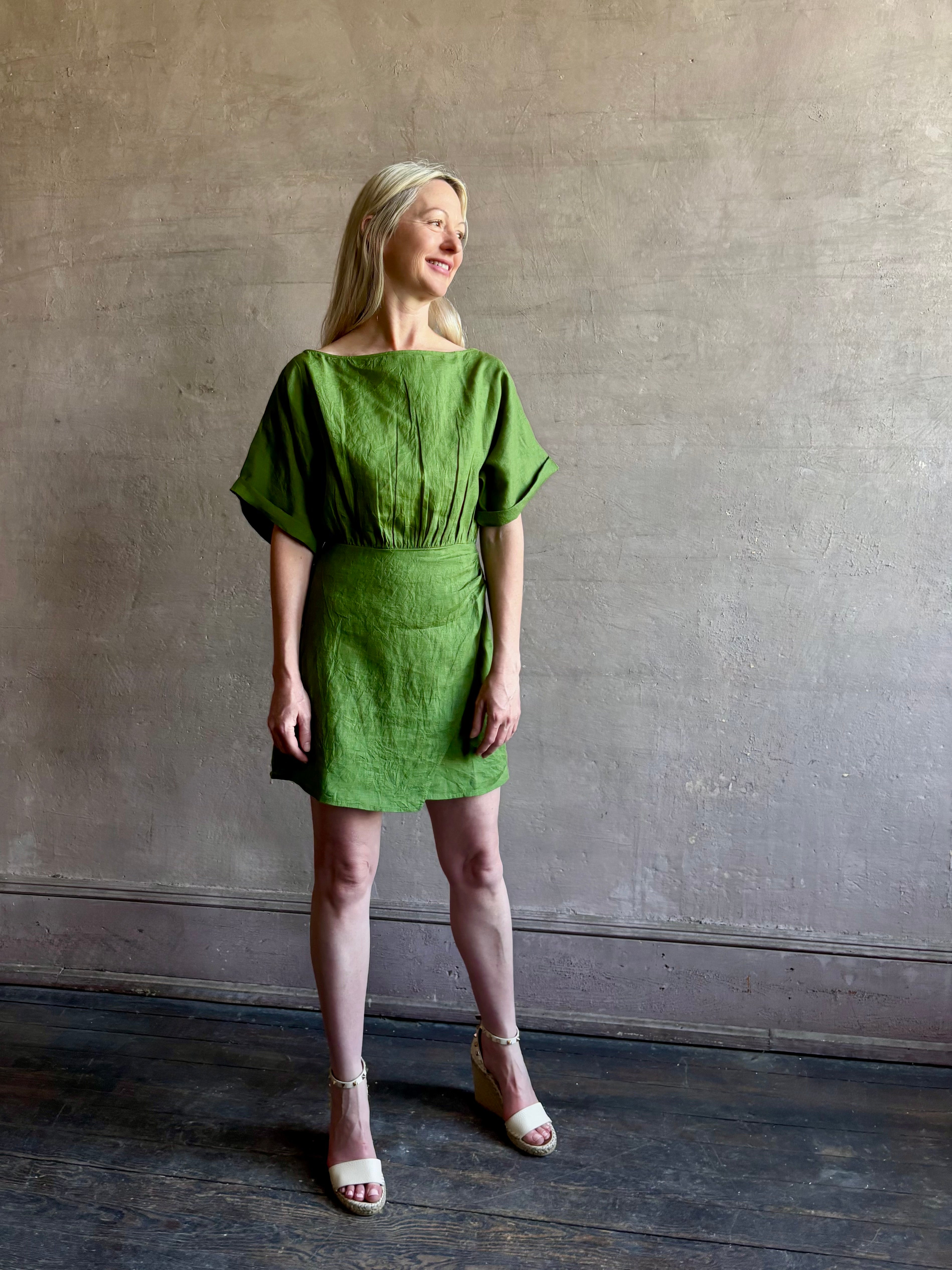 Mature woman wearing the effortlessly  Sigrun Mini summer Dress from Apiece Apart rendered in 100% linen with a boat neck, loose half sleeves and blouson style