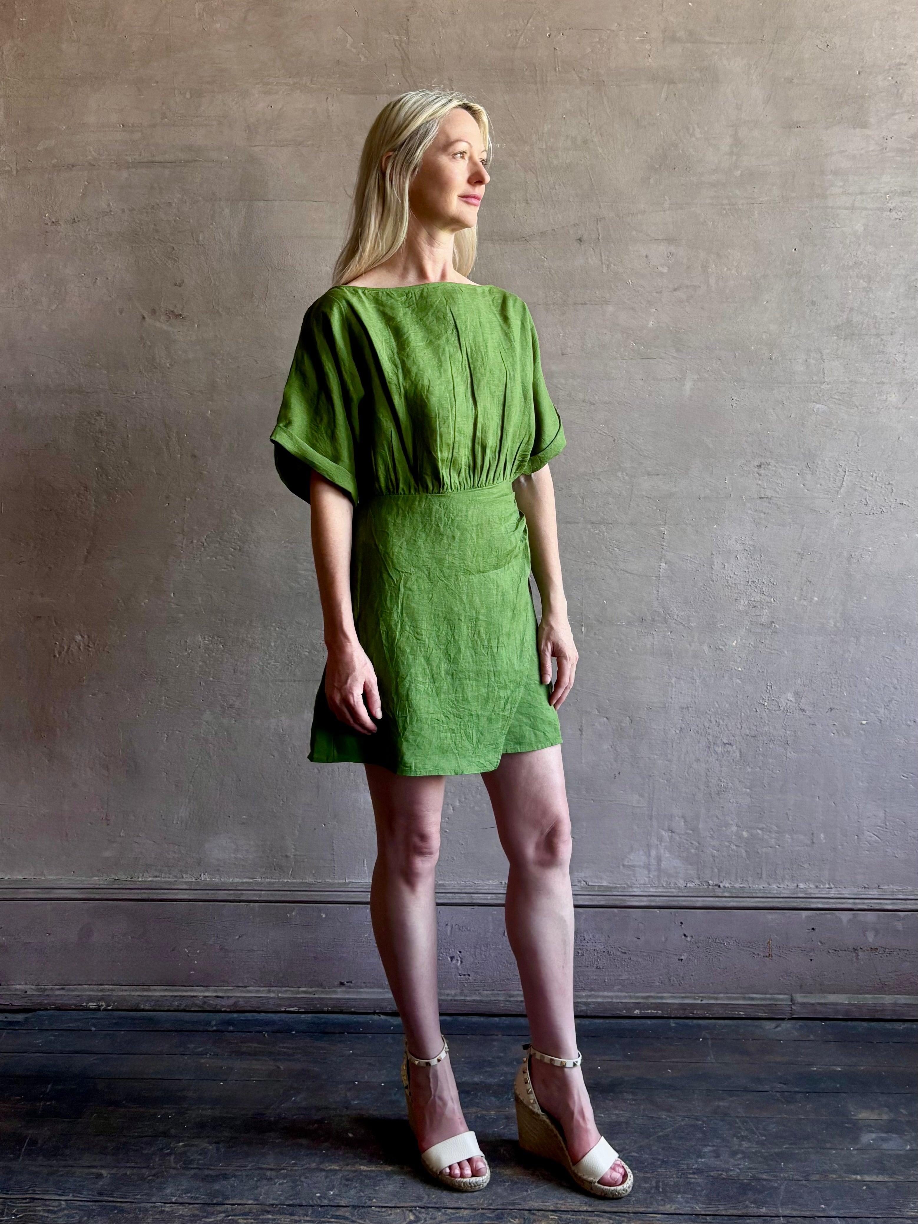 Mature woman wearing the effortlessly  Sigrun Mini summer Dress from Apiece Apart rendered in 100% linen with a boat neck, loose half sleeves and blouson style