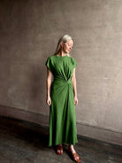 Mature woman wearing Volta Twist maxi Dress from Apiece Apart in a comfy green organic cotton jersey with short sleeves and crew neck