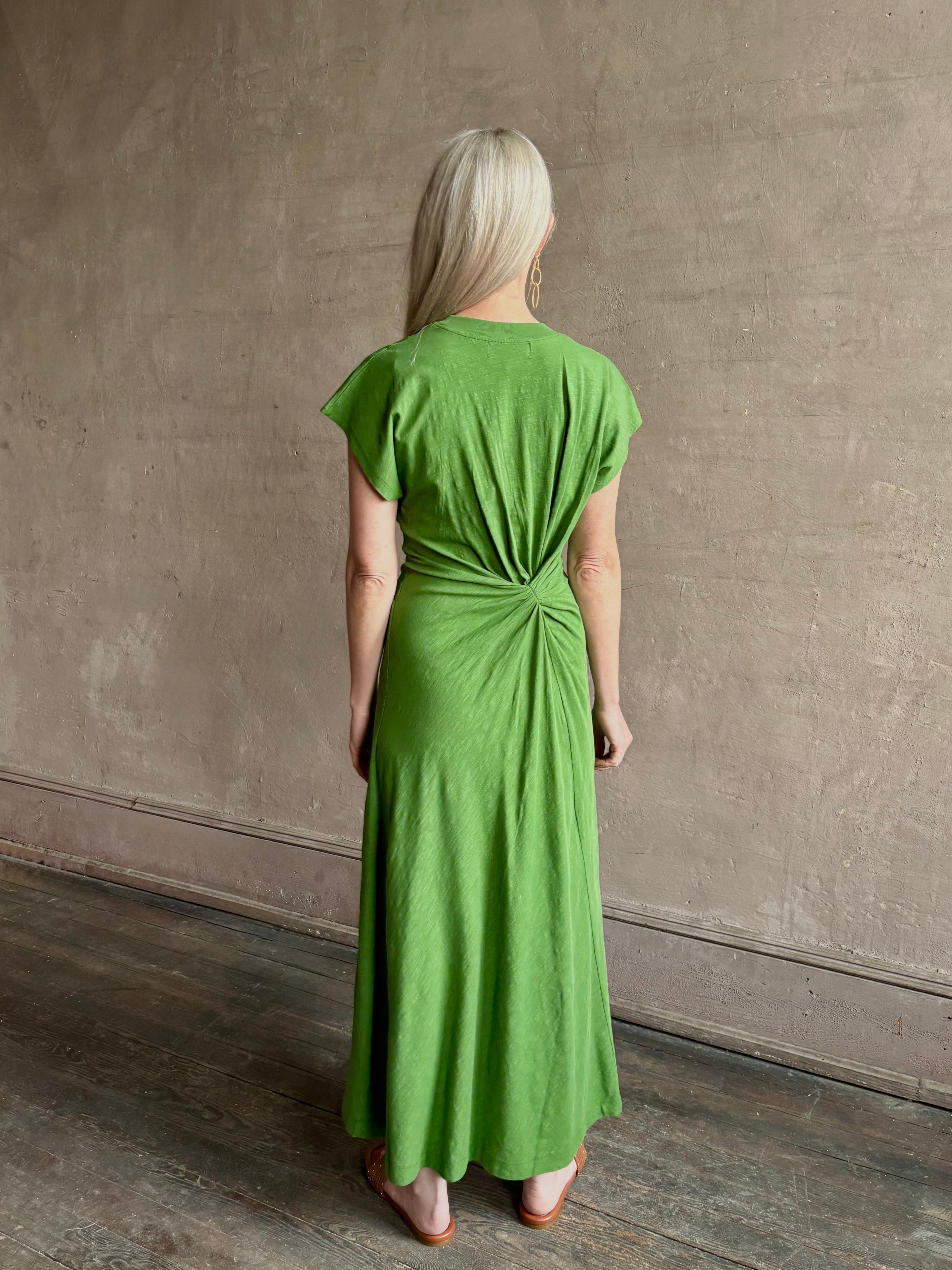 Mature woman wearing Volta Twist maxi Dress from Apiece Apart in a comfy green organic cotton jersey with short sleeves and crew neck