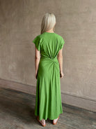 Mature woman wearing Volta Twist maxi Dress from Apiece Apart in a comfy green organic cotton jersey with short sleeves and crew neck