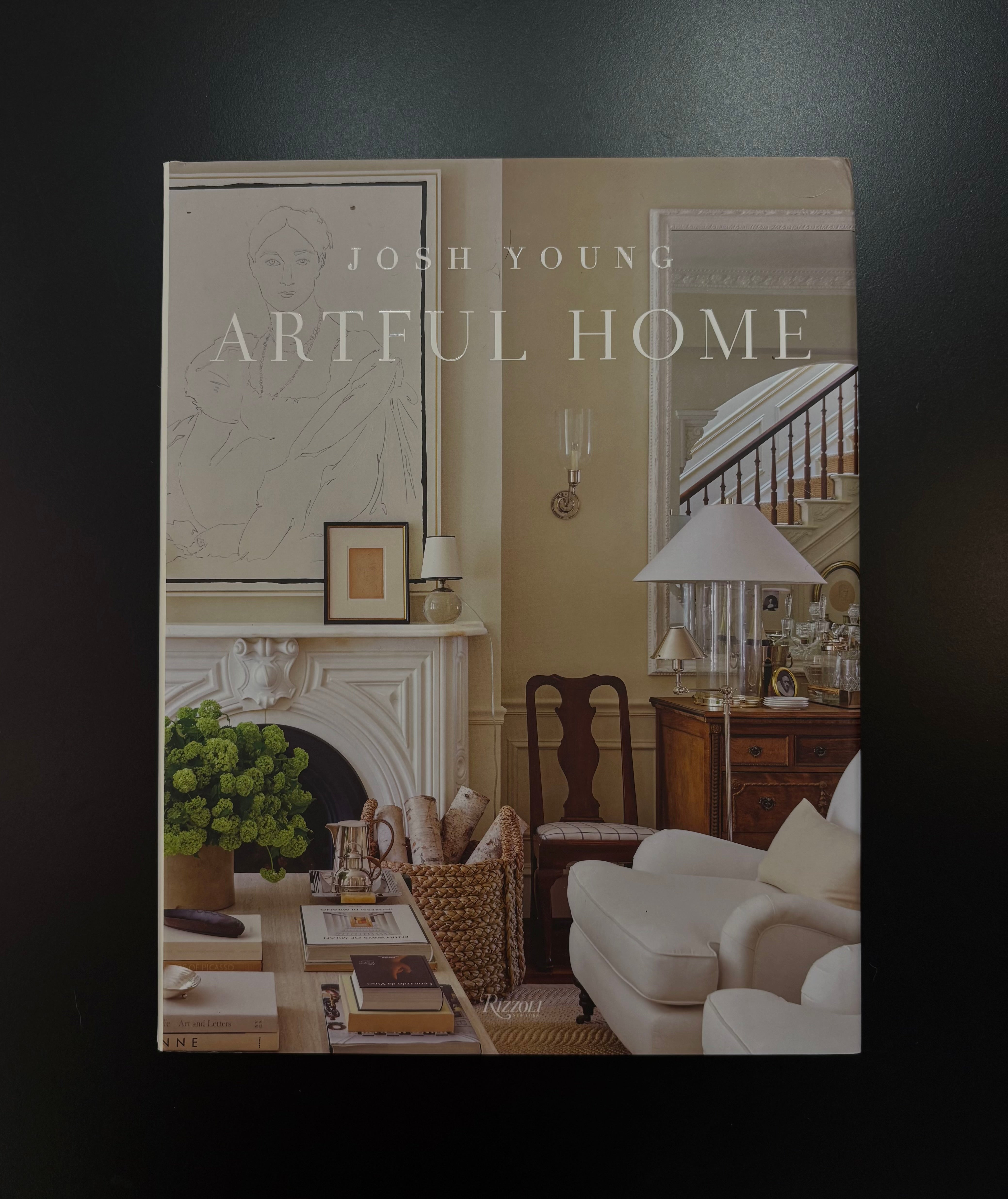 book cover of 'Artful Home' by Josh Young, featuring a warm-toned classic living room with a fireplace, armchair, and desk.