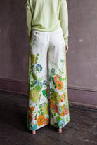 Image featuring a woman wearing the Constance pants by Alemais with a high rise and allover floral print, side stripes and pockets.