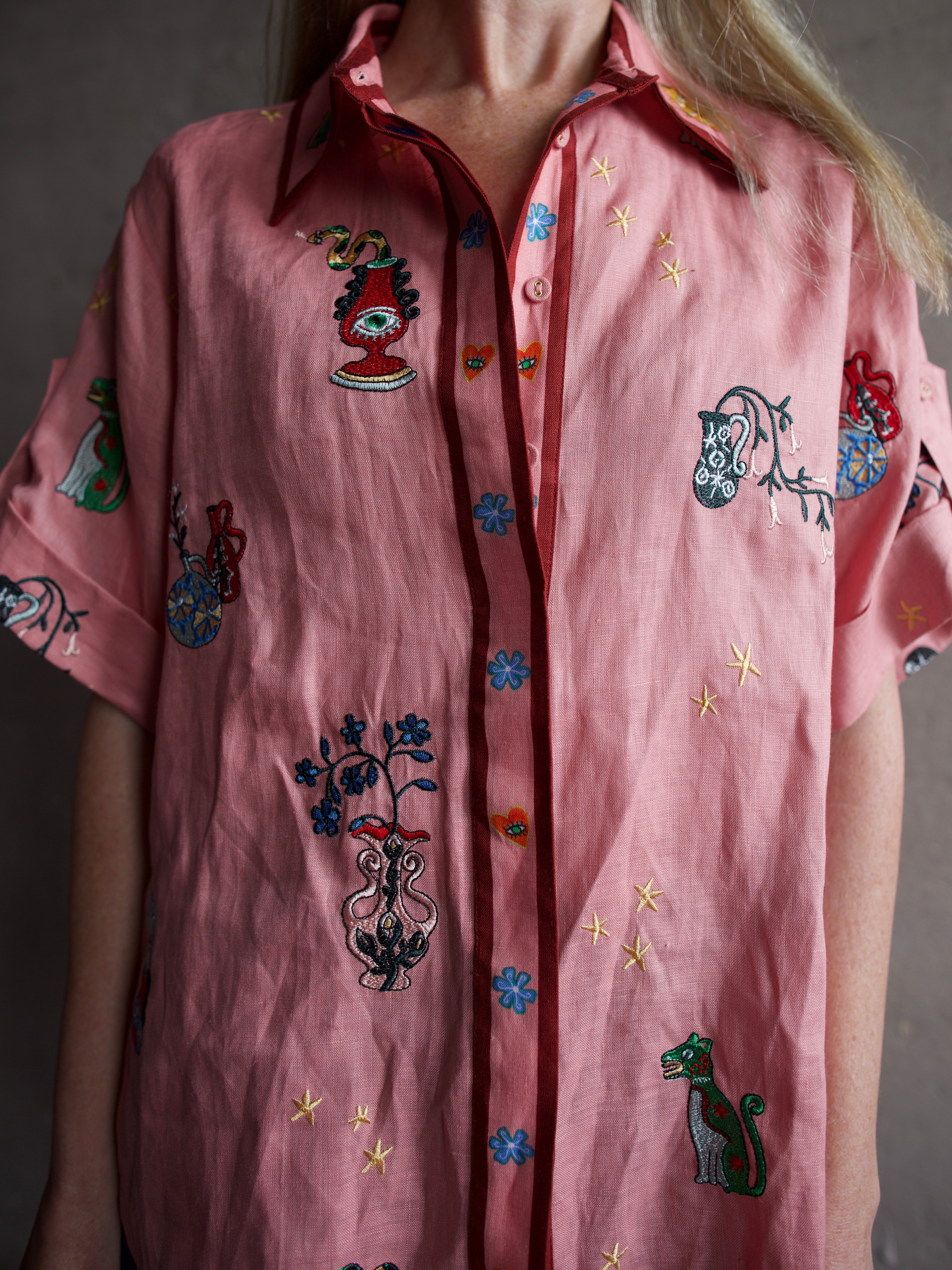 The closeup image of a woman wearing the Alemais Timmy embroidered shirt