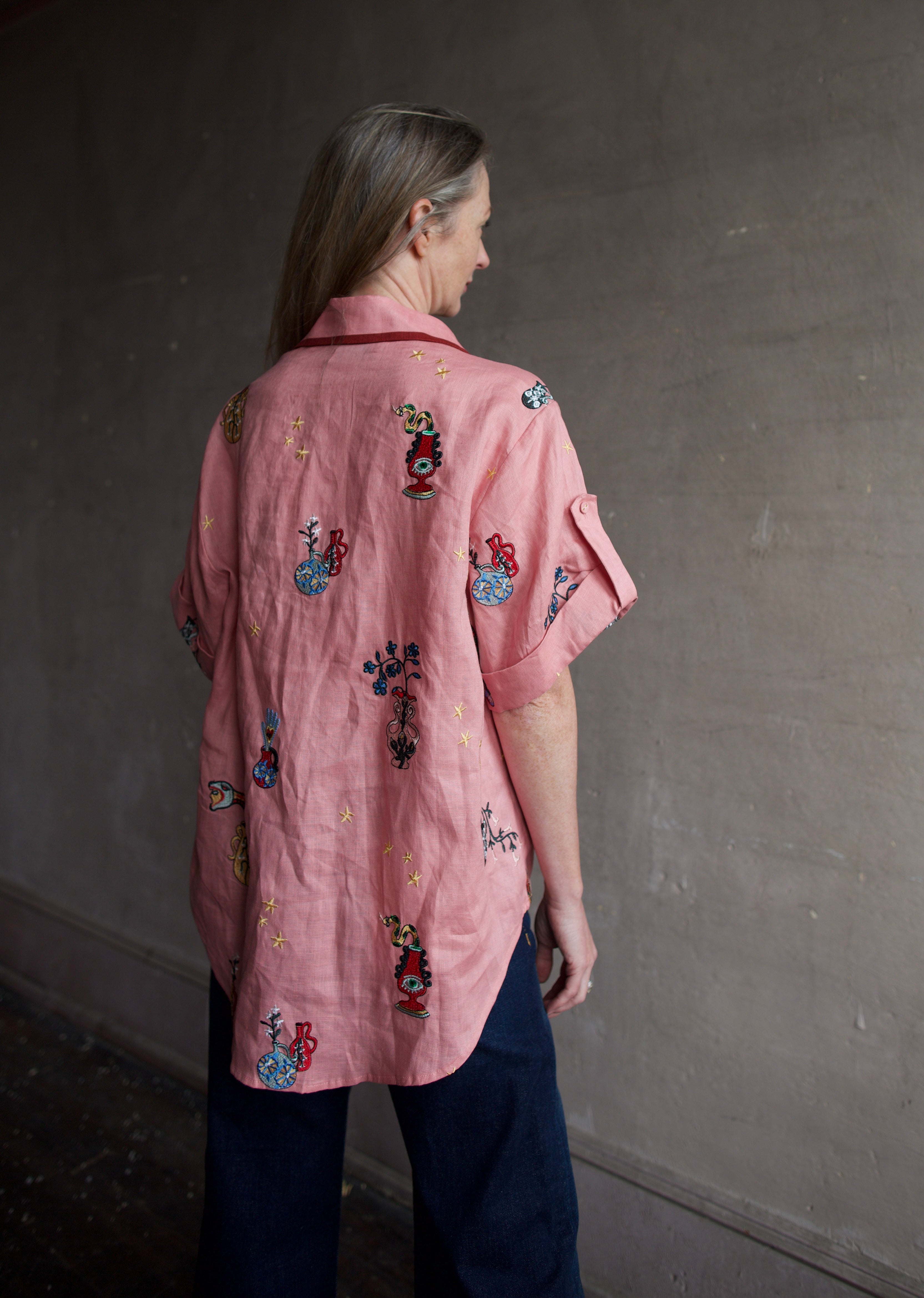 Image of the back of a woman wearing the Alemais Timmy embroidered shirt and Re/Done Wide Leg crop jeans