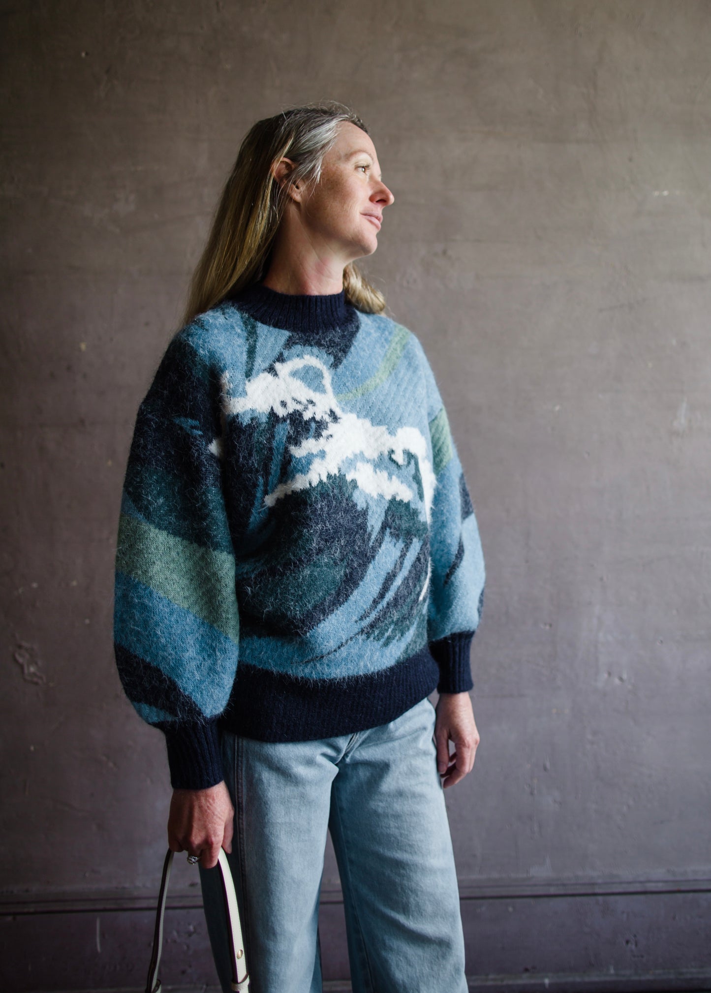 Image featuring a woman wearing the Wave knit sweater by Alemais with chunky texture with a wave pattern and full sleeves.