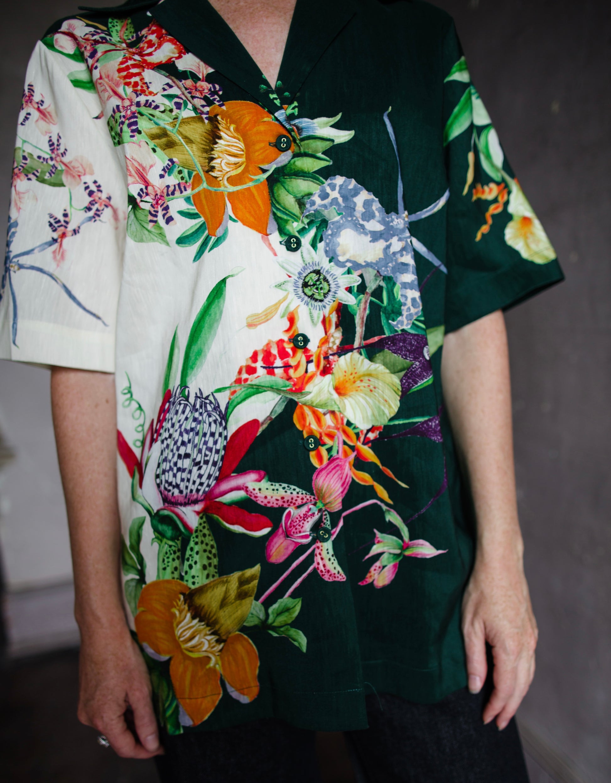 Image featuring a woman wearing the linen blend Aggie top by Alemais with a button front and boxy fit and an allover tropical floral print in green multi-color.
