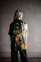 Image featuring a woman wearing the linen blend Aggie top by Alemais with a button front and boxy fit and an allover tropical floral print in green multi-color.